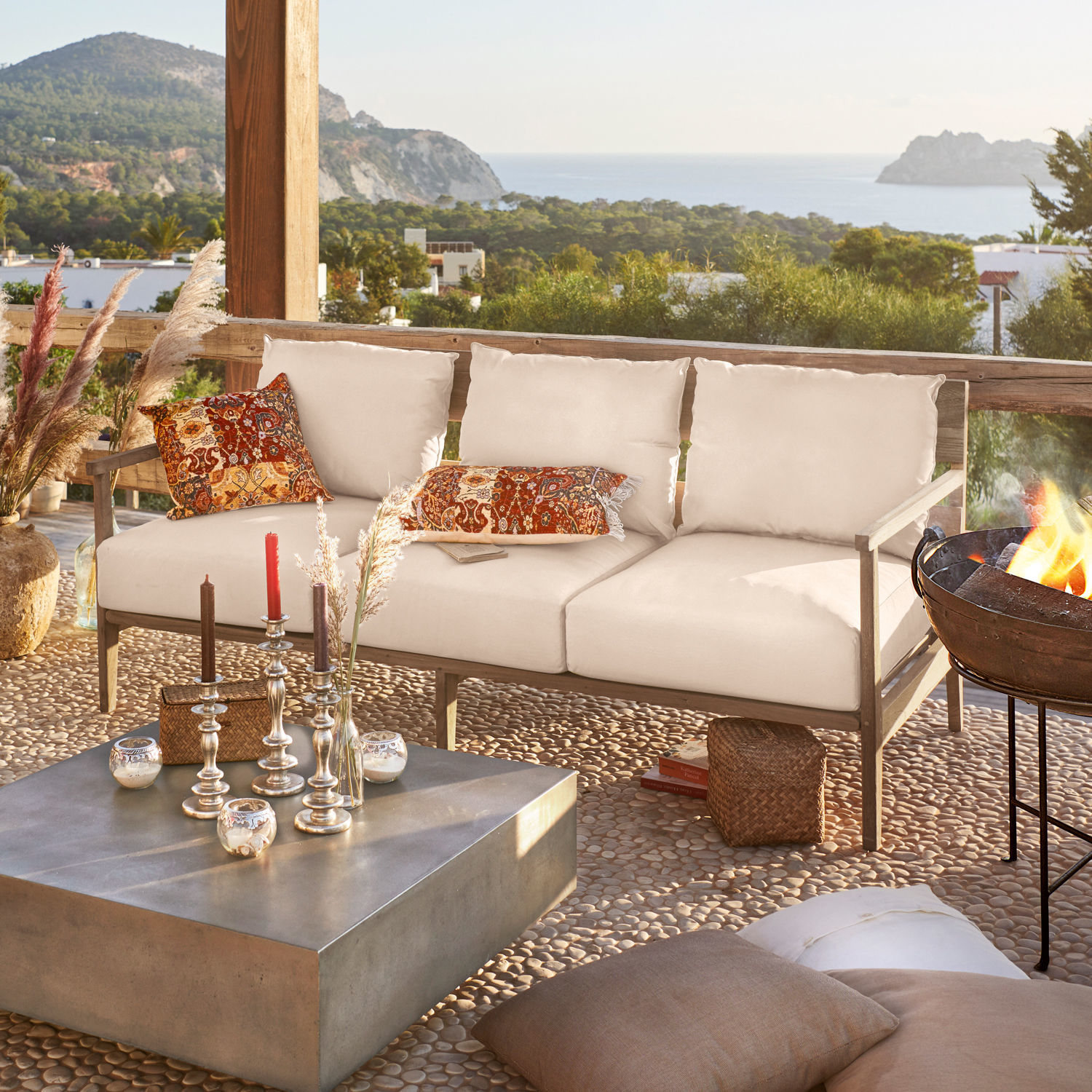 Sofa Kingsbridge Beige Outdoor-Sofa mit Holzrahmen und bunten Kissen auf Terrasse mit Meerblick