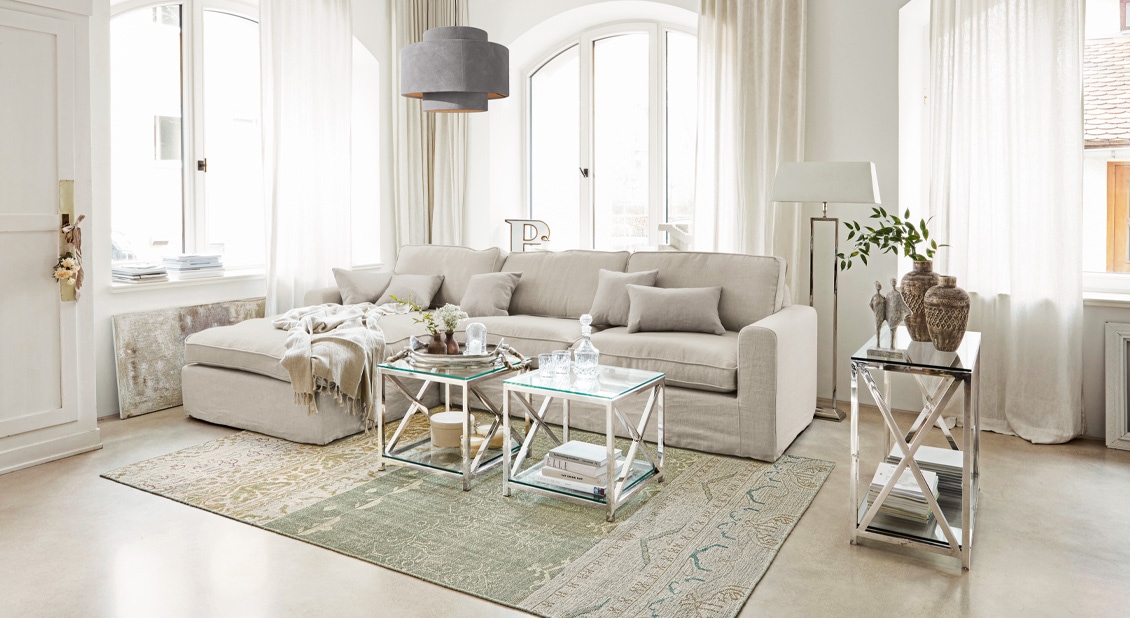 Beige Sofa im Leinen-Look mit Kissen und Metall-Tischen in hellem Wohnzimmer