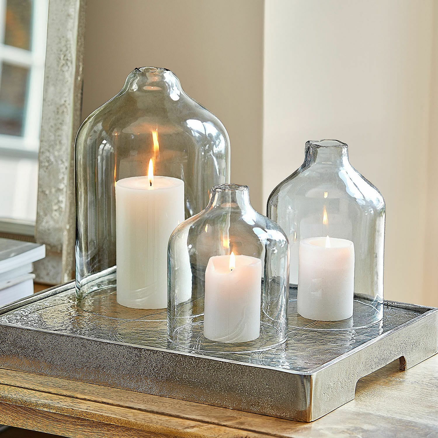 Windlicht 3er Set Xalvent Set aus drei transparenten Glasglocken mit weißen Kerzen auf dekorativem Metalltablett