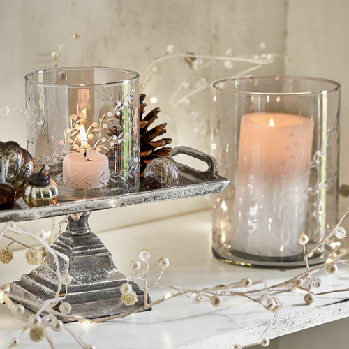 Glaswindlichter mit weißen Kerzen auf Metallständer im rustikalen Stil, festliche Dekoration