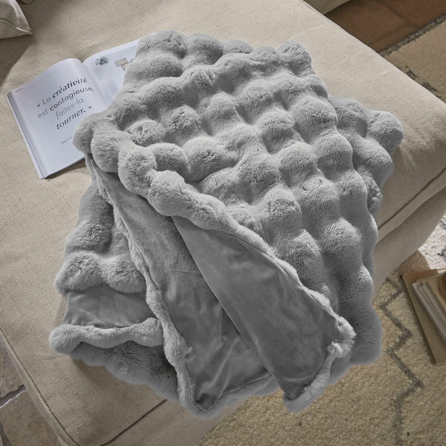 Plaid Zalina Weiche graue Kuscheldecke mit Fellmuster auf beigem Sofa, ideal für Dekoration und Wärme