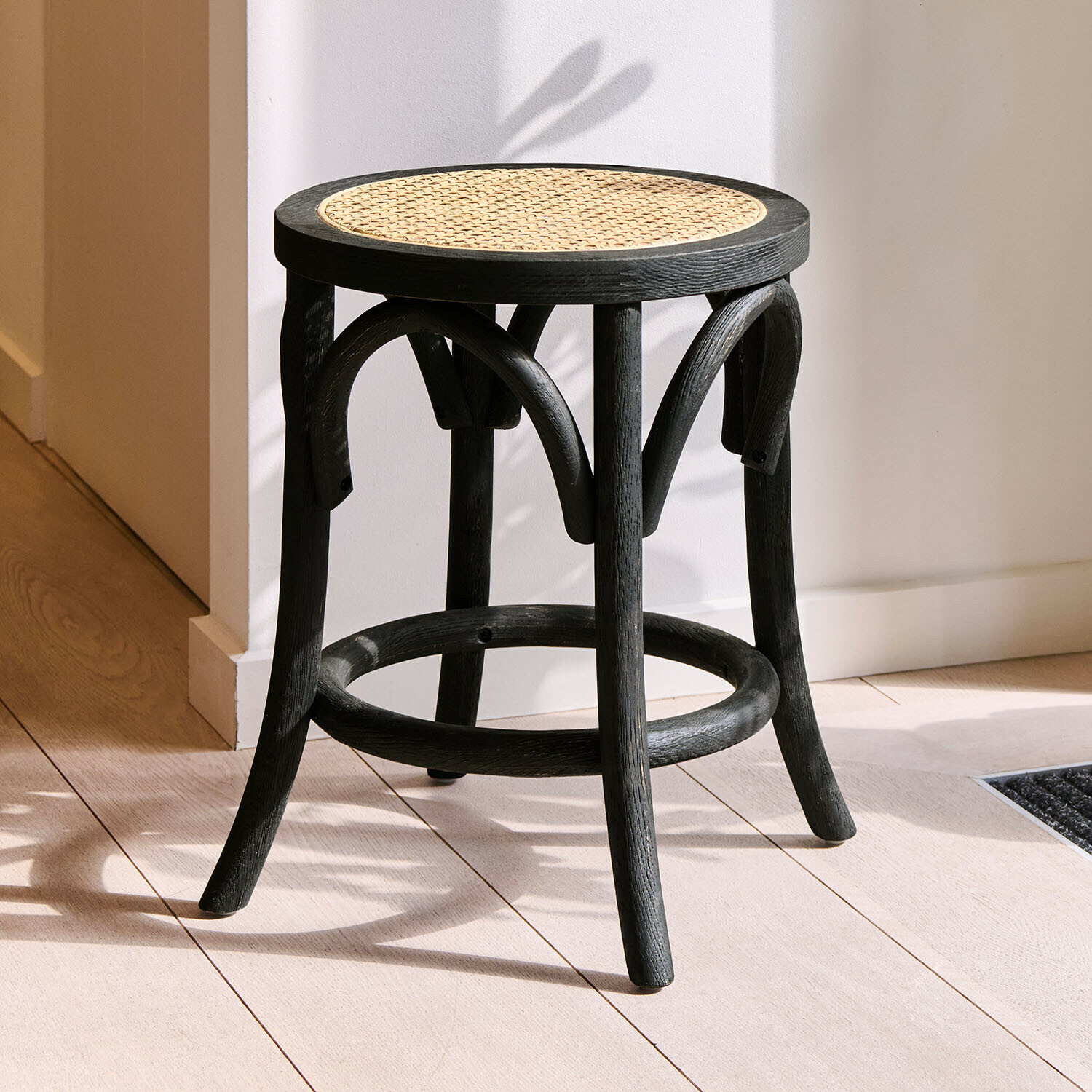 Hocker Kary Schwarzer Holzhocker mit rundem Geflecht-Sitz, moderner Sitzmöbel für Wohnräume