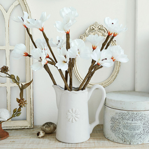 Weißer Keramikkrug mit dekorativen weißen Blumen auf Holztisch, Vintage-Stil, Wohnaccessoire