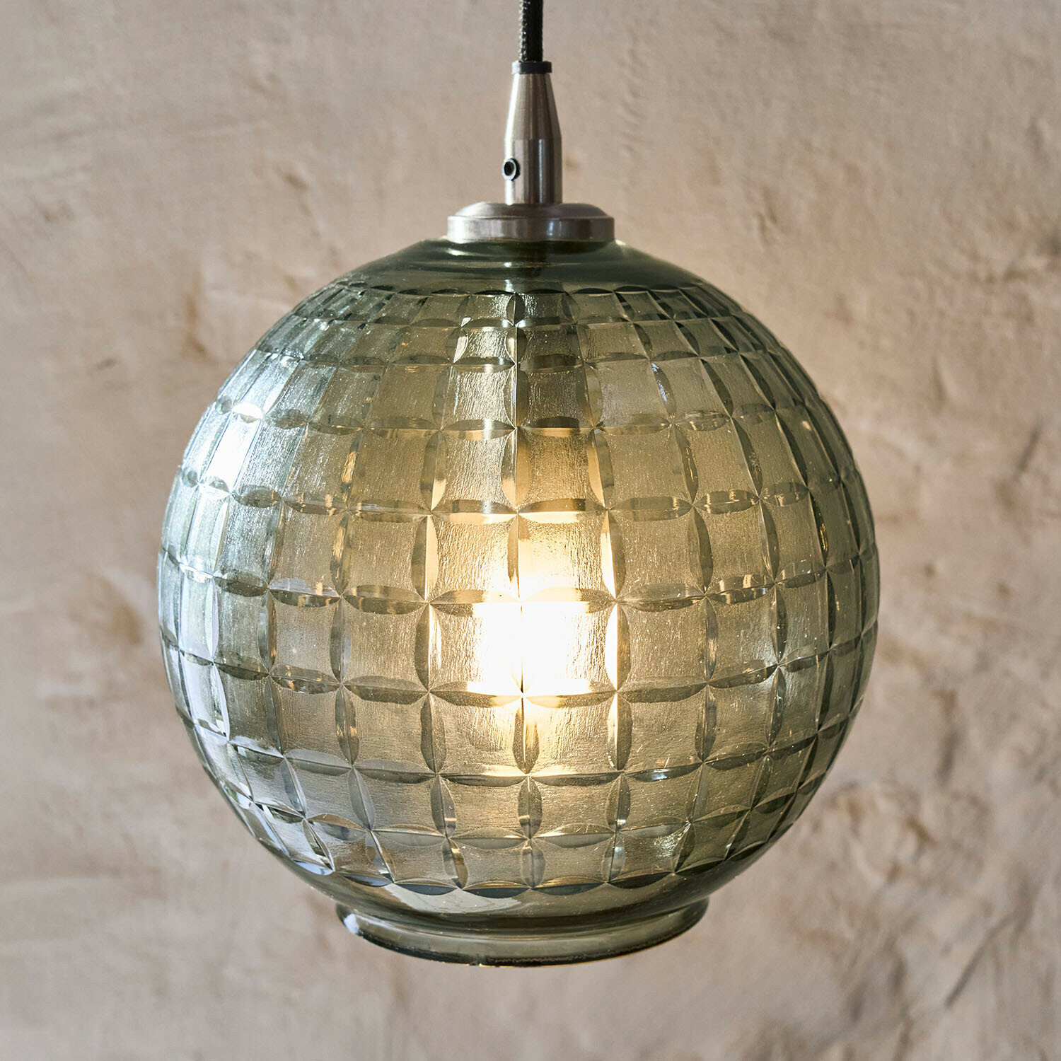 Grüne, strukturierte Glaskugel als Pendelleuchte, modernes Wohnraumlicht mit Muster