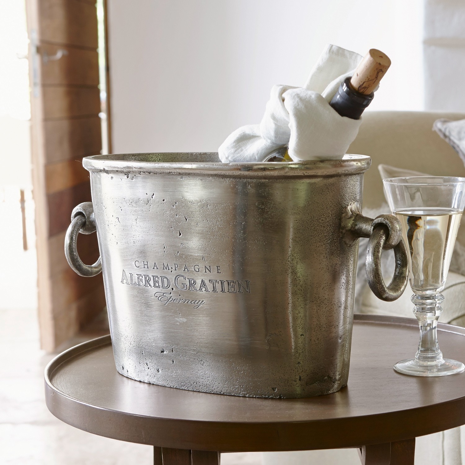 Sektkühler Alfred Metall Champagnerkühler in Silber mit Griffen und Flasche auf rundem Tisch