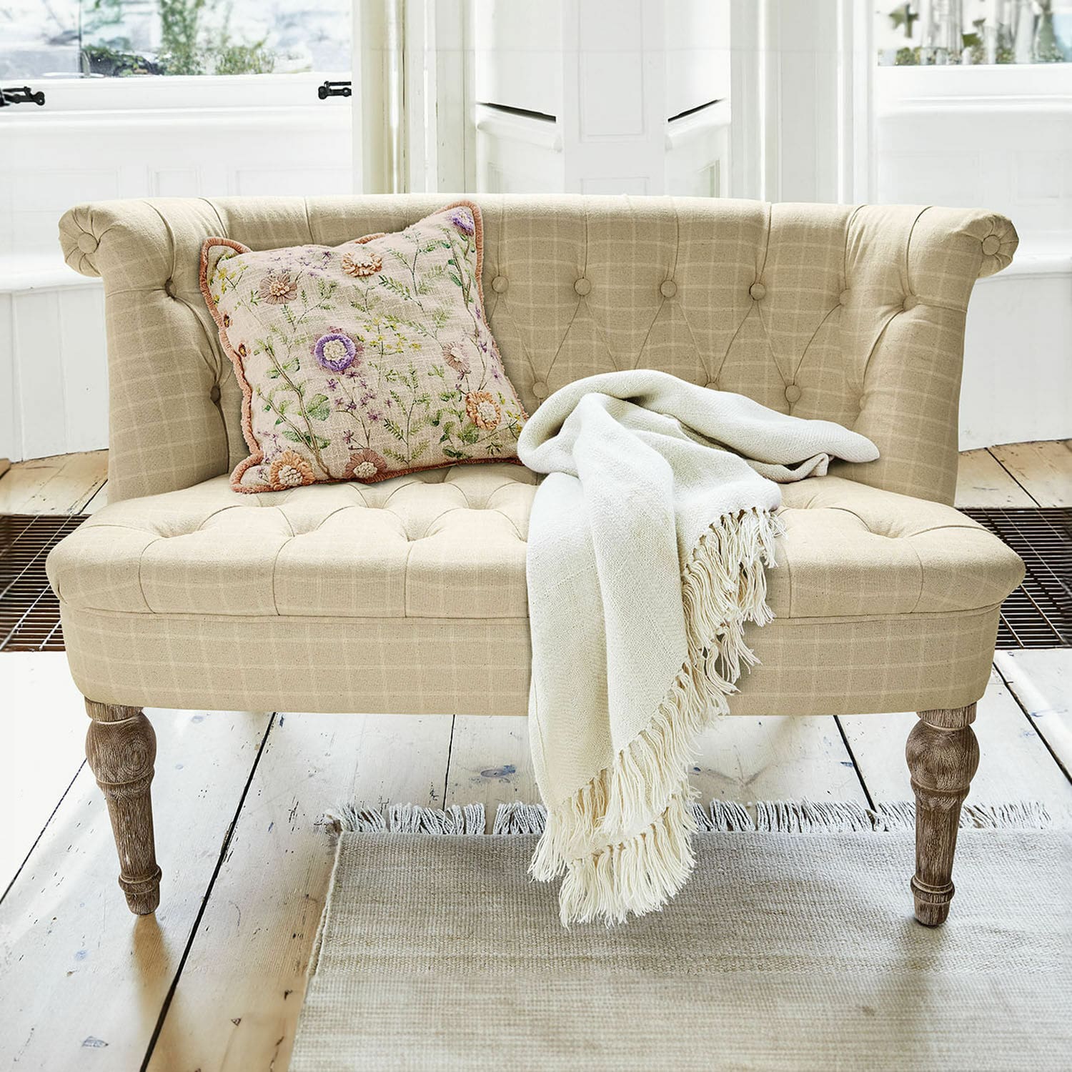 Sofa Weralin Beige gepolstertes Sofa mit Holzbeinen, dekorativem Kissen und cremefarbenem Plaid auf hellem Teppich