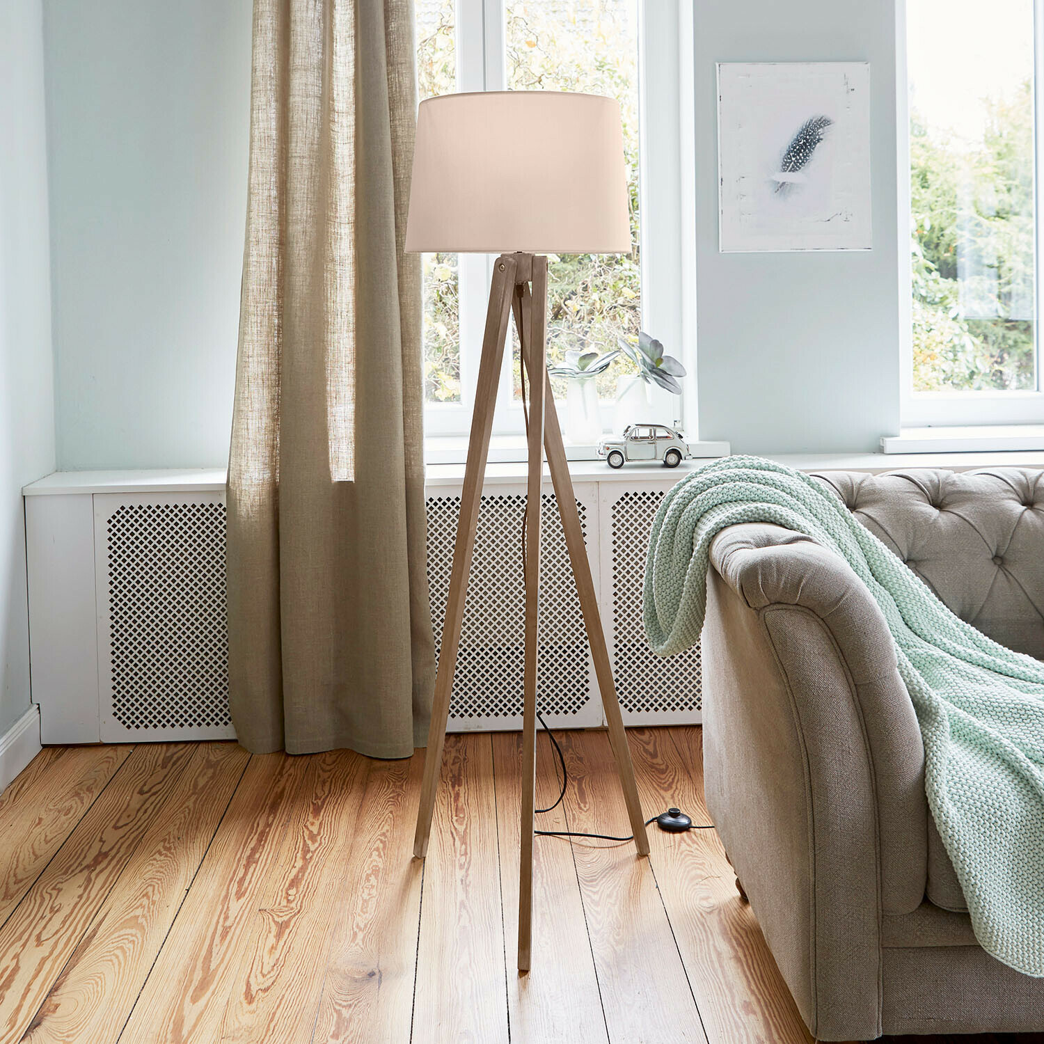 Stehlampe Troisième Stehlampe mit Holzgestell und cremefarbenem Lampenschirm in hellem Wohnzimmer mit Sofa und Decke