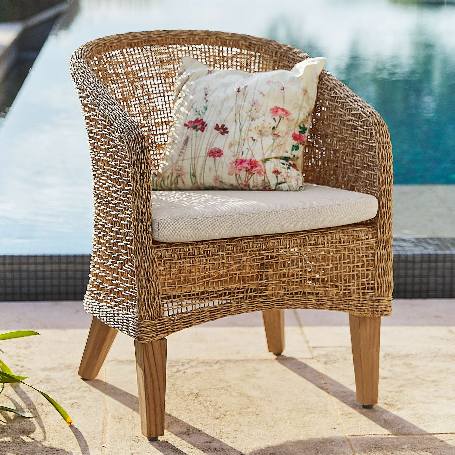 Sessel Redcliffe Rattansessel mit hellem Polster und floralem Kissen, ideal für Garten und Terrasse