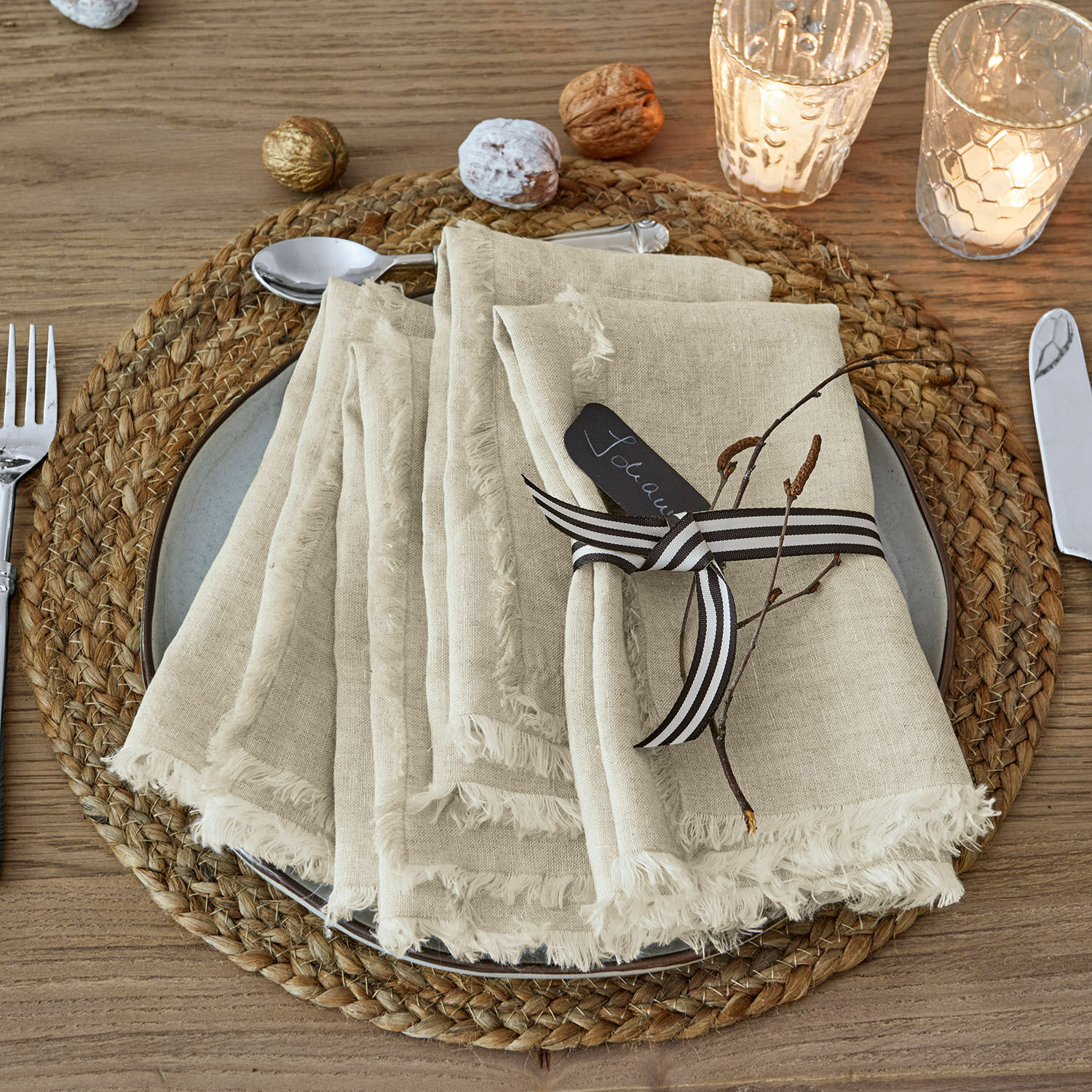 Serviette 4er Set Largo Beige Leinenservietten mit Fransen auf geflochtenem Platzset aus Holz mit weihnachtlicher Dekoration