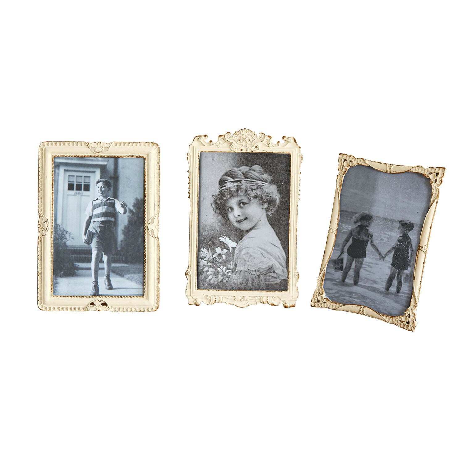Drei cremefarbene Bilderrahmen mit Verzierungen und schwarz-weißen Retro-Kinderfotos