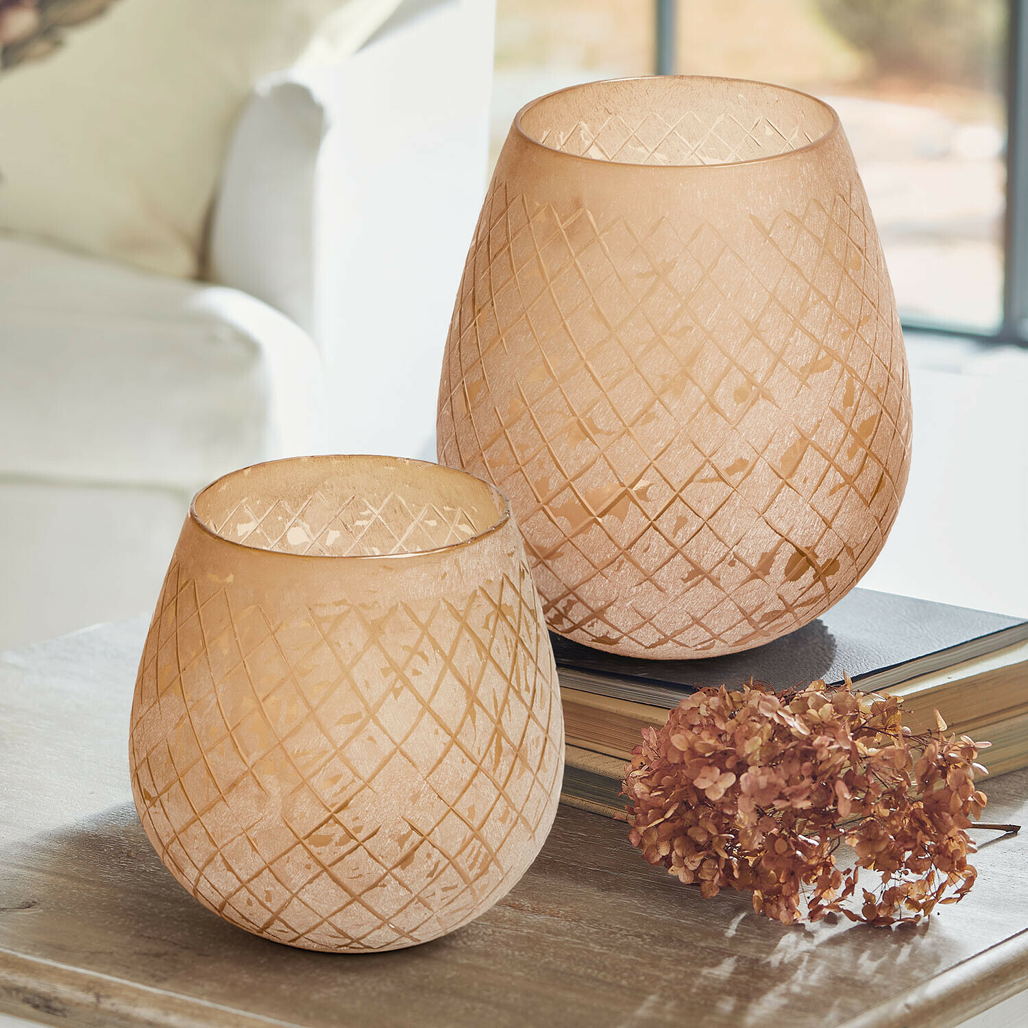 Windlicht 2er Set Méloriane Zwei beige Glaswindlichter mit geometrischem Muster auf Holztisch mit getrockneten Blumen