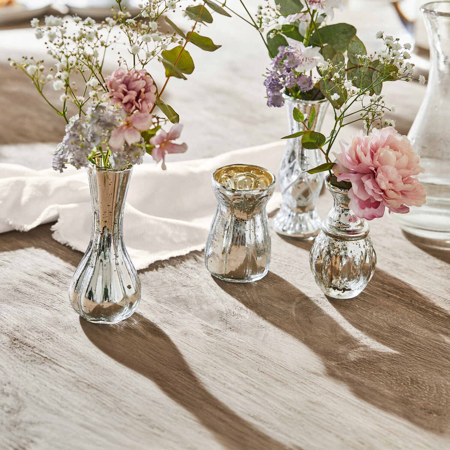 Deko-Vase 4er Set Maelie Vier silberne Glasvasen mit Blumen auf Holztisch, stilvolle Tischdekoration im Vintage-Stil