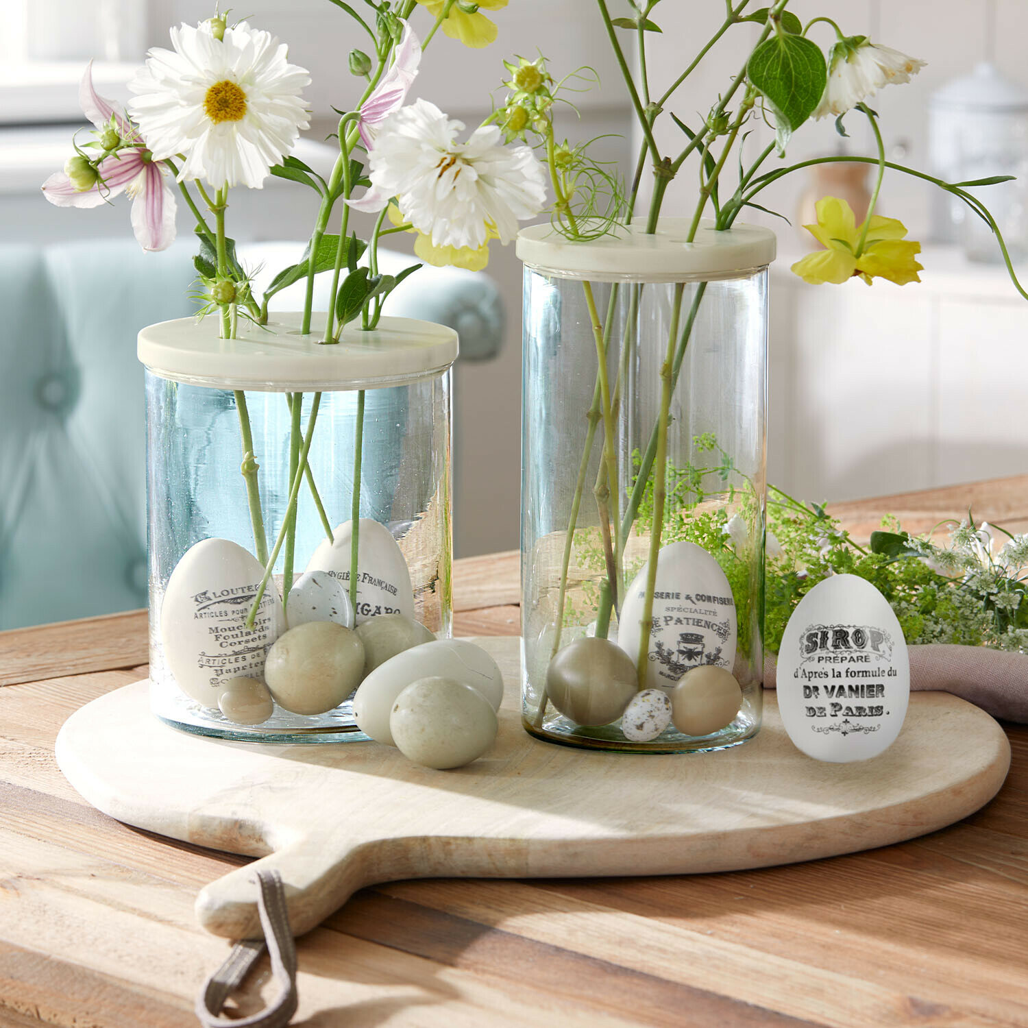 Osterei 4er Set Maison Vélour Glasvasen mit weißen und beigen Dekoeiern und Blumen auf einem Holzbrett als Tischdeko