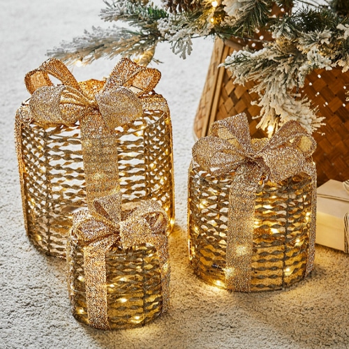 Drei goldene Geschenkdekorationen mit LED-Beleuchtung für festliche Wohnraumgestaltung