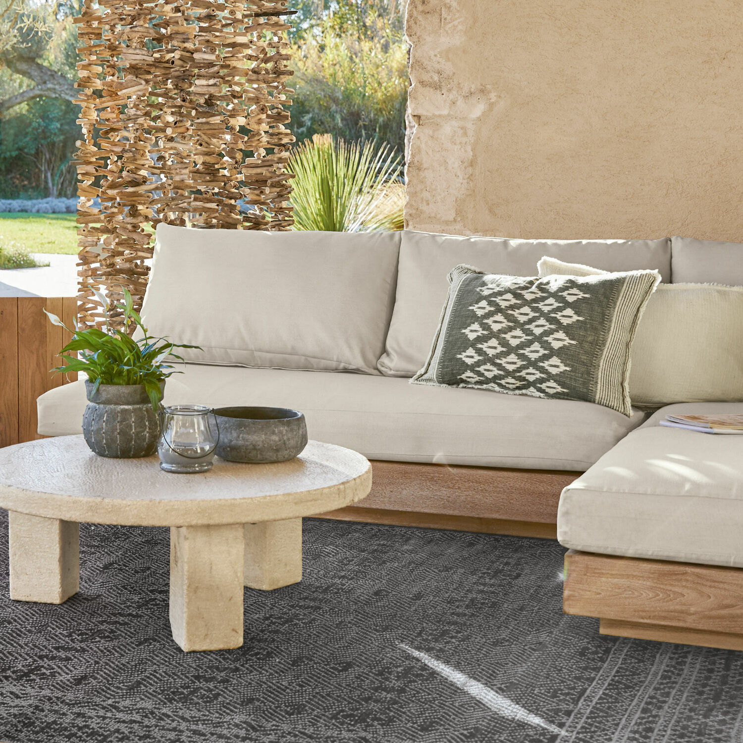 Sofaelement Courtelevant Beige Sofa mit Holzuntergestell und dekorativem Kissen auf schwarzem Teppich im Wohnzimmer.