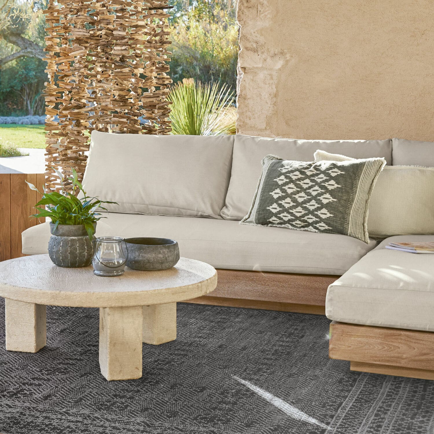 Sofaelement Courtelevant Beige Sofa mit Holzuntergestell und dekorativem Kissen auf schwarzem Teppich im Wohnzimmer.