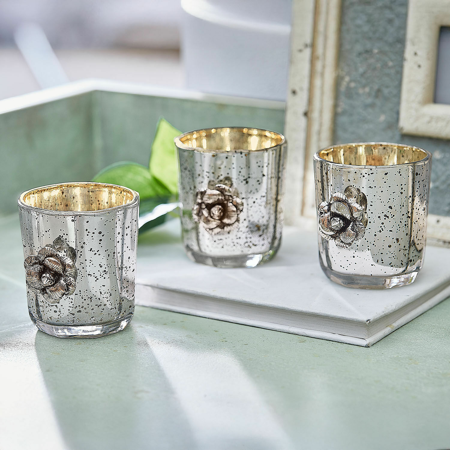 Teelichthalter 3er Set Alovix Drei silberne Glas-Teelichthalter mit goldfarbenem Innenraum und metallischer Blumendekoration