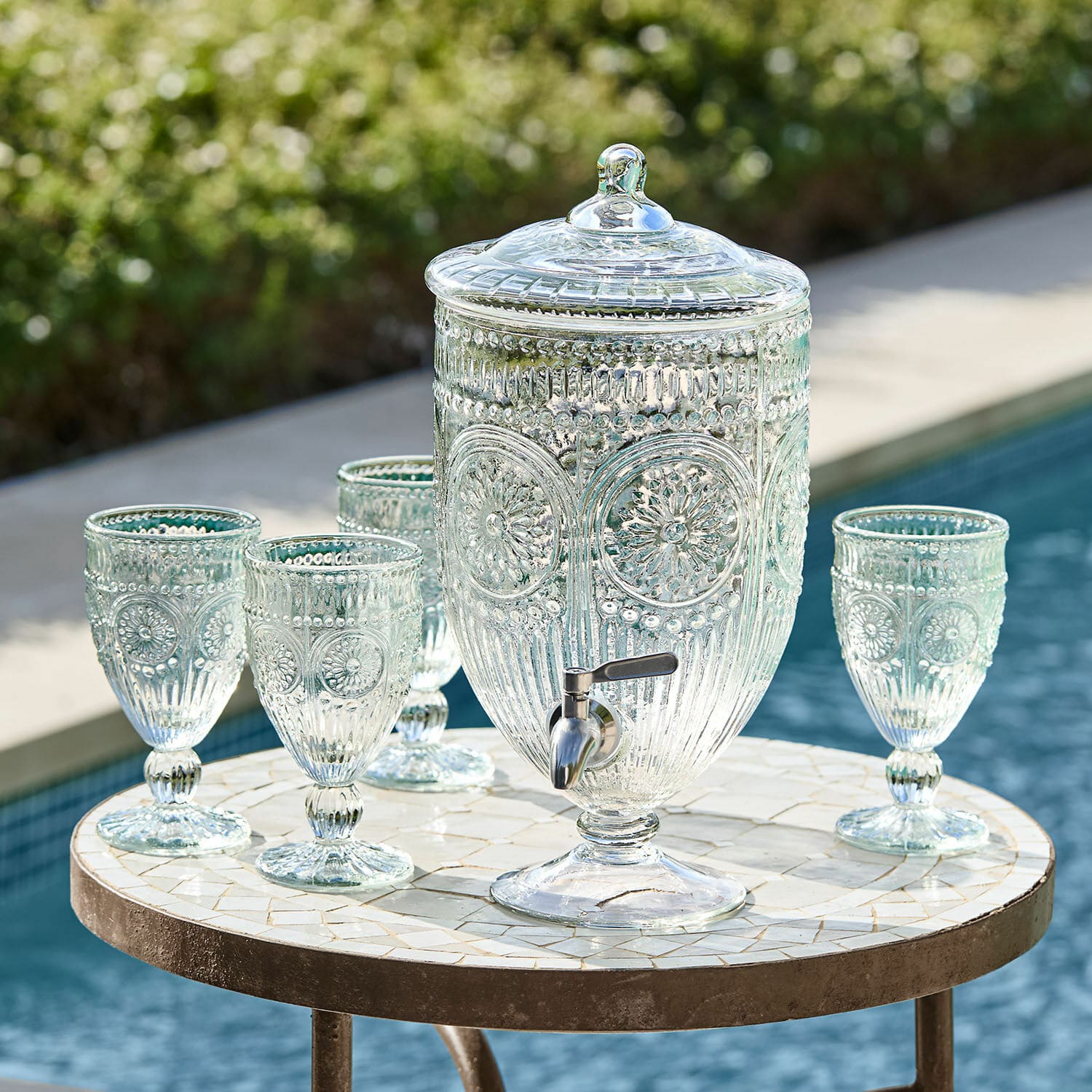 Getränkespender Mercure Glas-Getränkespender mit Deckel und Zapfhahn sowie vier passende Gläser auf Mosaiktisch am Pool