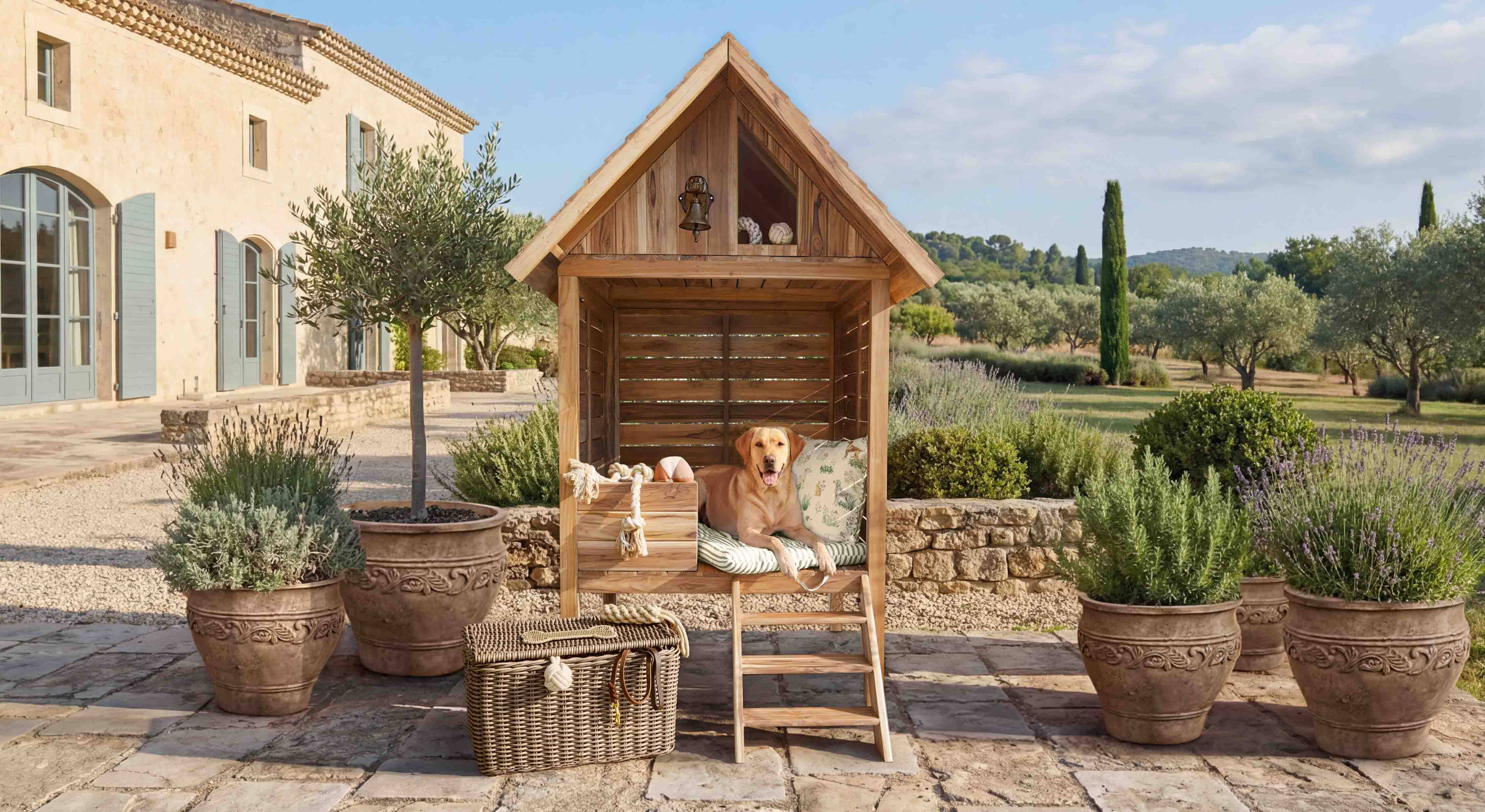 Holz-Hundehütte mit Kissen und Leiter auf Terrasse mit Pflanzen in Töpfen im Garten