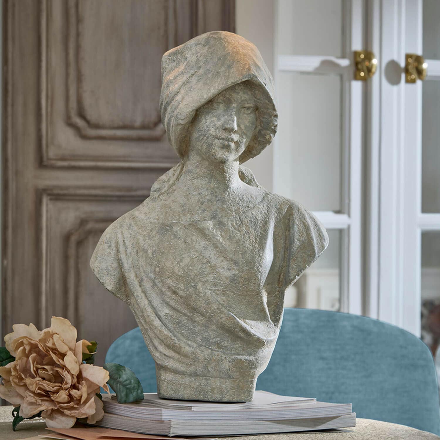 Graue Steinstatue einer Frau als Büste auf einem Buchstapel mit Blume, elegante Wohnraumdekoration