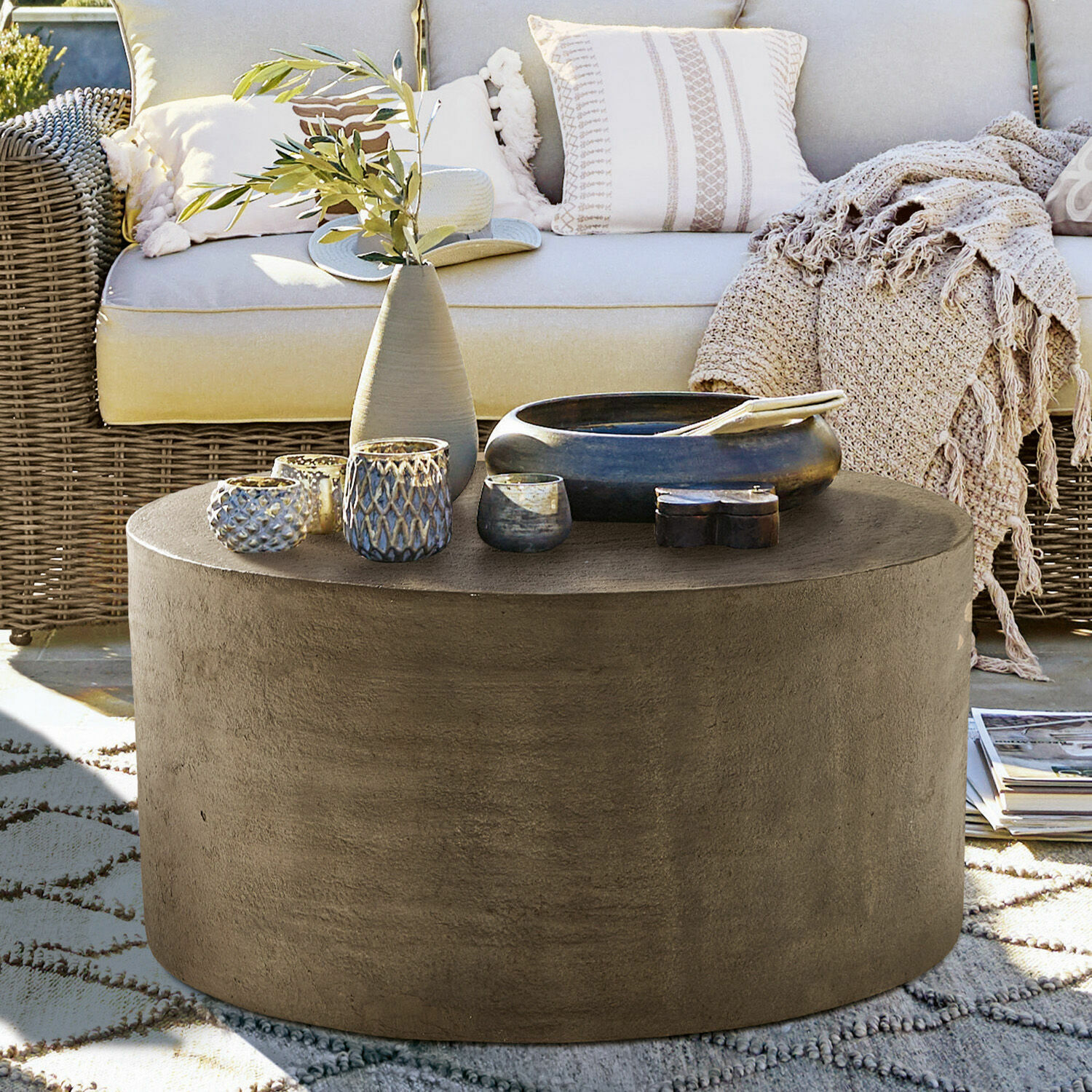 Couchtisch Lexy Runder Couchtisch aus grauem Beton auf Terrasse mit Dekorationen und Rattansofa