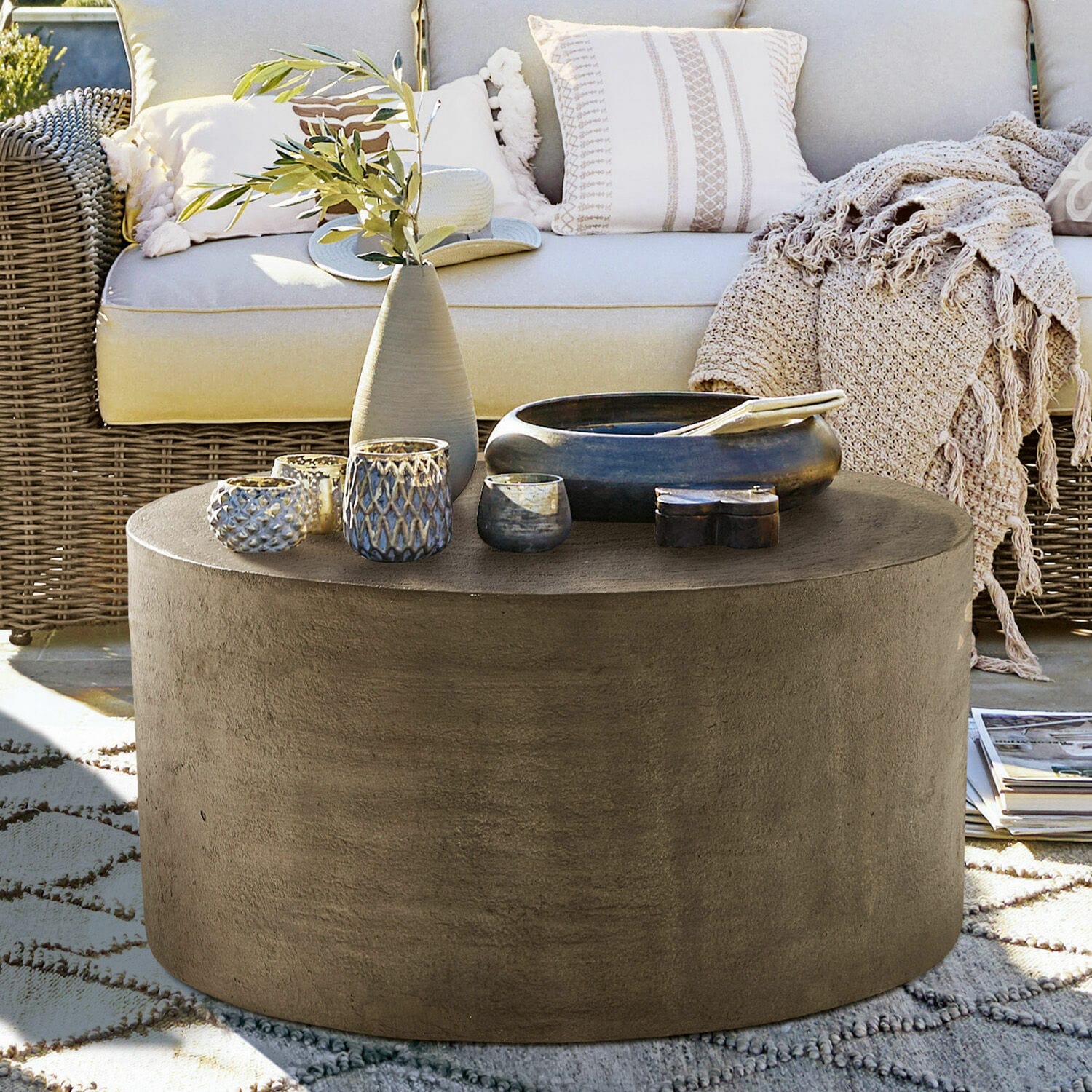 Couchtisch Lexy Runder Couchtisch aus grauem Beton auf Terrasse mit Dekorationen und Rattansofa