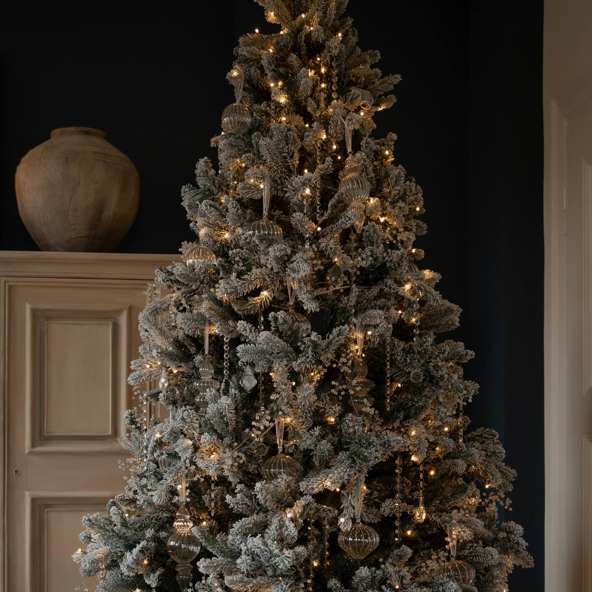 Künstlicher Weihnachtsbaum mit schneebedeckten Zweigen und warmweißen LED-Lichtern zur festlichen Dekoration
