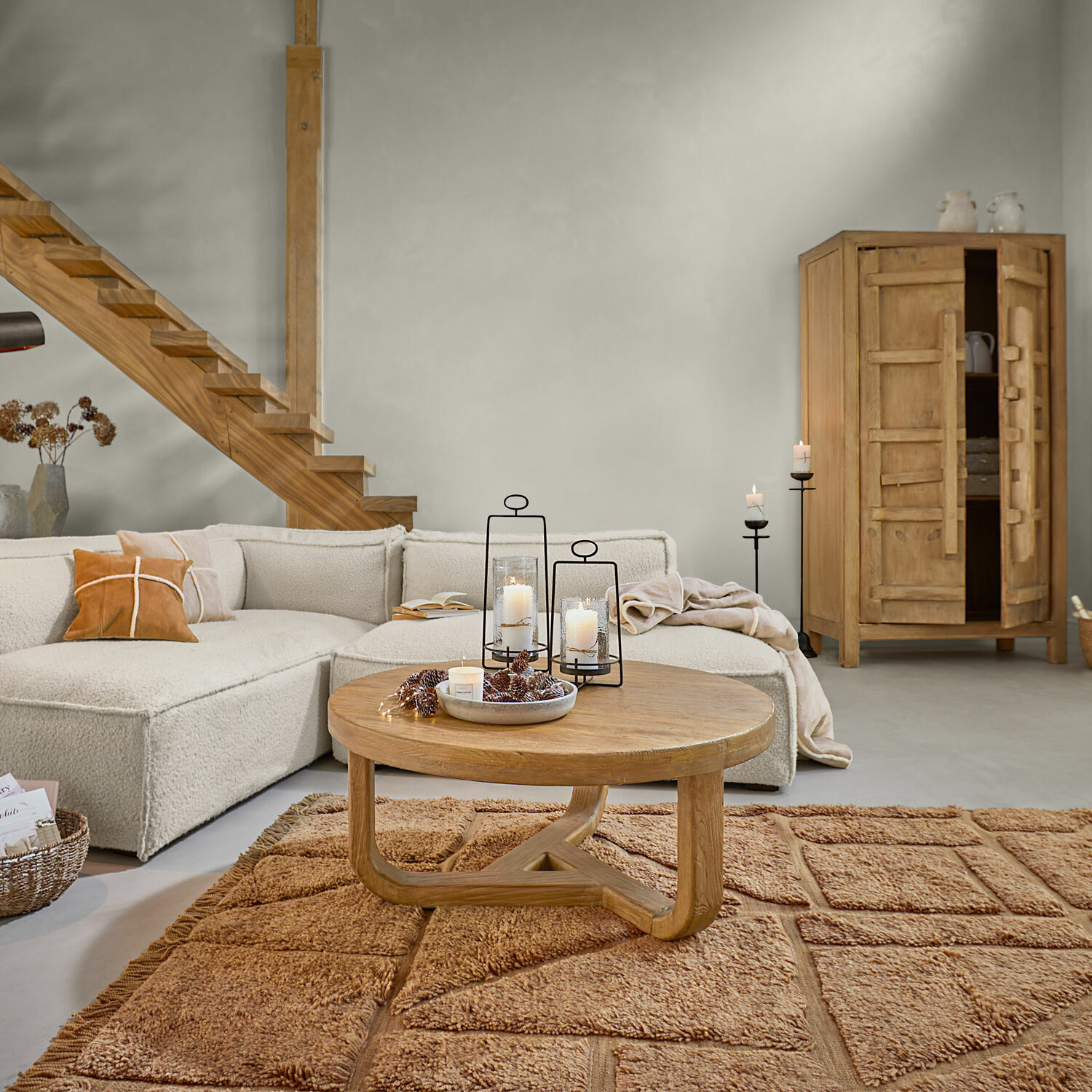 Modernes Wohnzimmer mit beigem Sofa, runden Holztisch und warmbraunem Teppich für gemütliches Ambiente