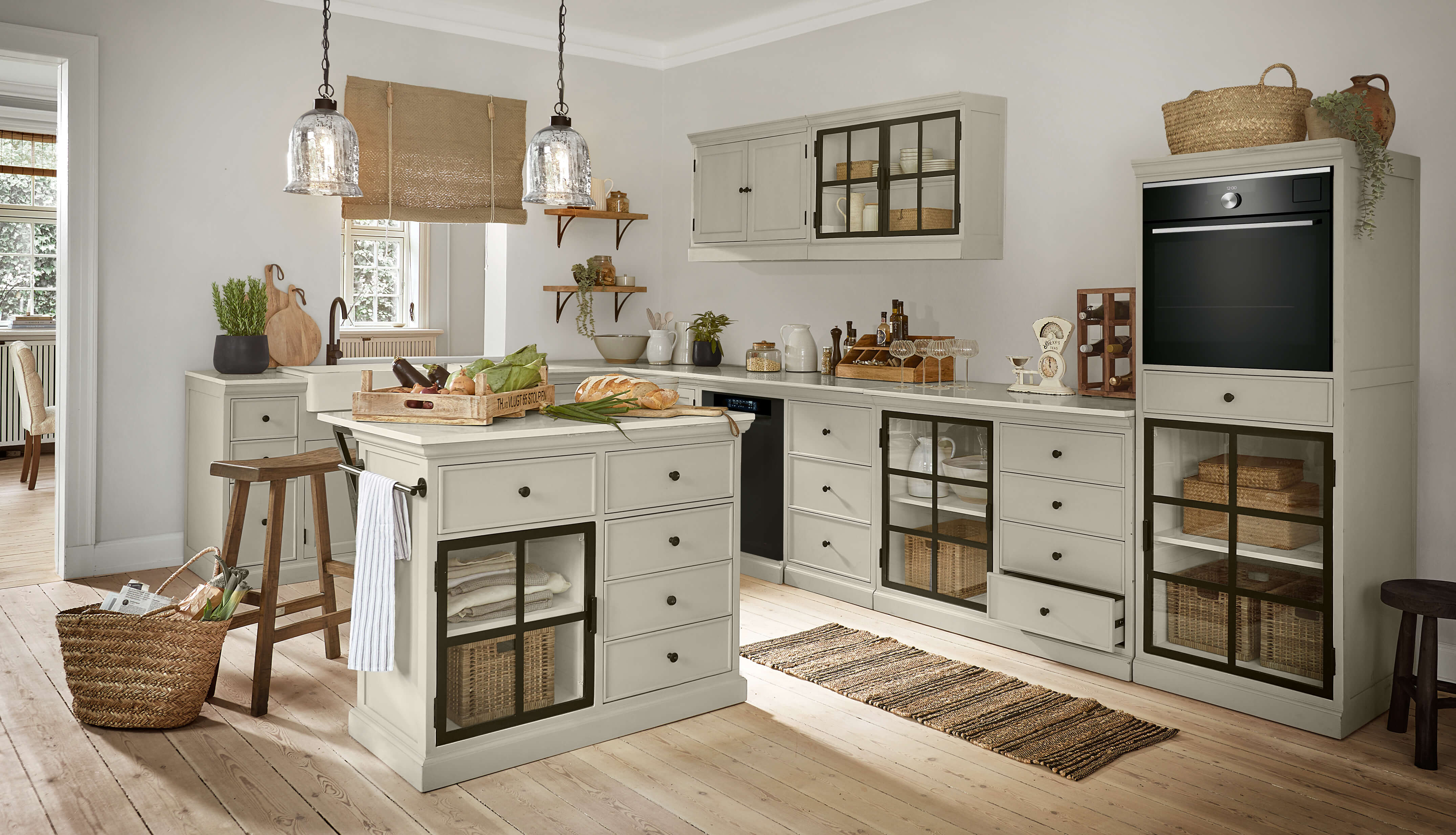 Rustikale Küche mit grauen Holzschränken und schwarzen Glastüren, heller Holzboden und Landhausstil