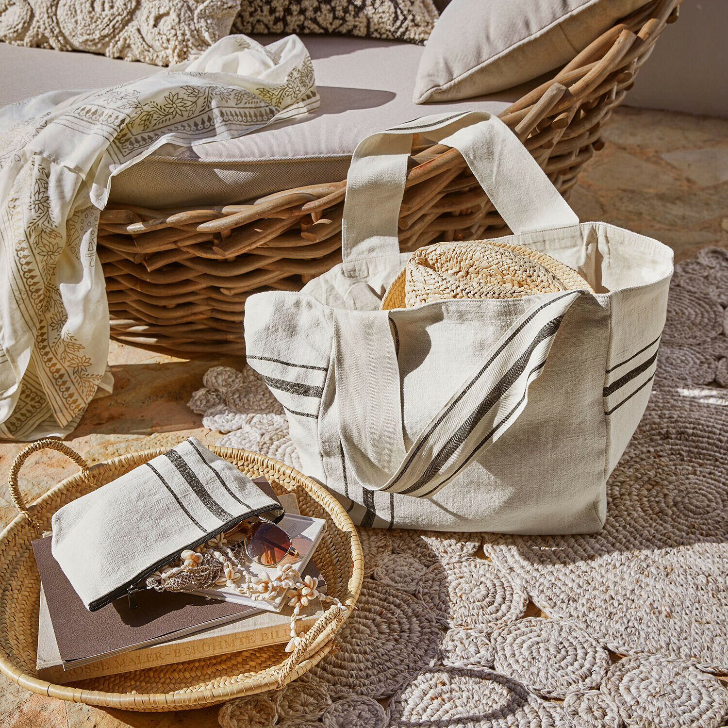 Tasche 2er Set Bravenda Beige Baumwolltasche mit Streifen und Strohhut vor Korbsessel und Teppich im Sonnenlicht