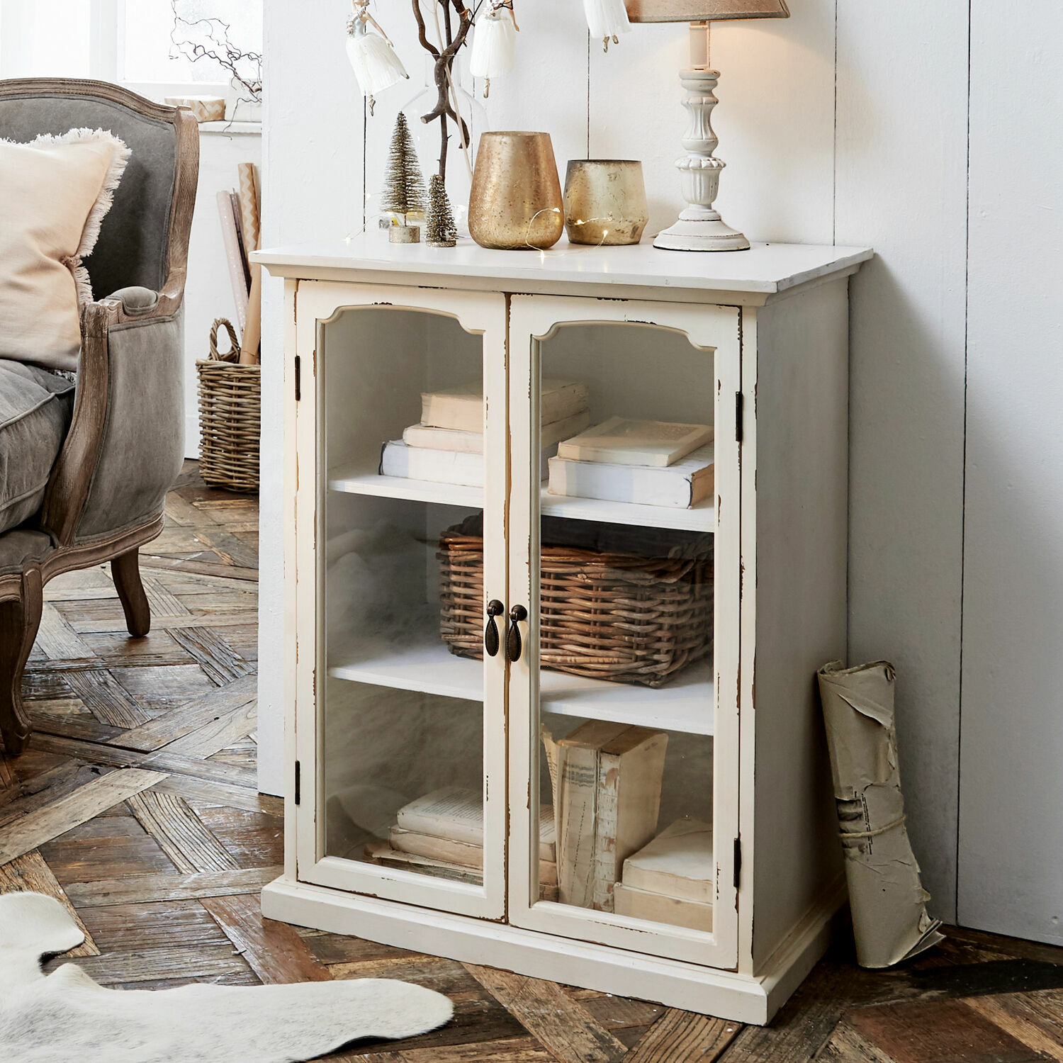 Weiße Holzvitrine mit Glastüren und Regalen voller Bücher im Vintage-Stil