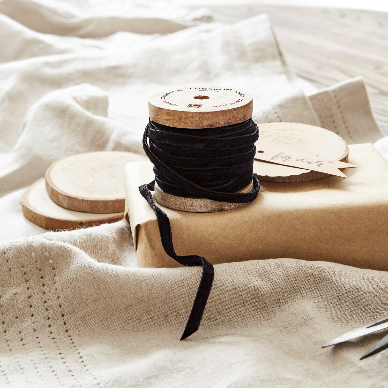 Samtband Olessa Schwarzes Samtband auf Holzspule mit Naturpapier und Schere zum Geschenkverpacken