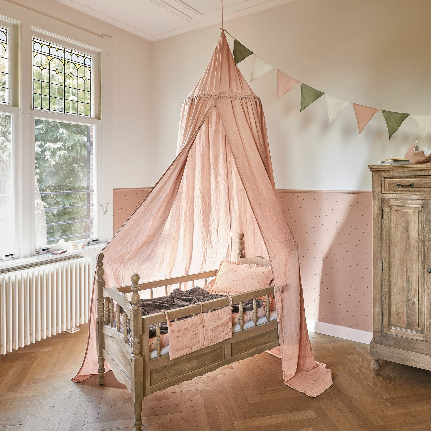 Betthimmel Lisonne Kinderbett aus Holz mit rosa Baldachin und dekorativen Kissen in hellem Kinderzimmer
