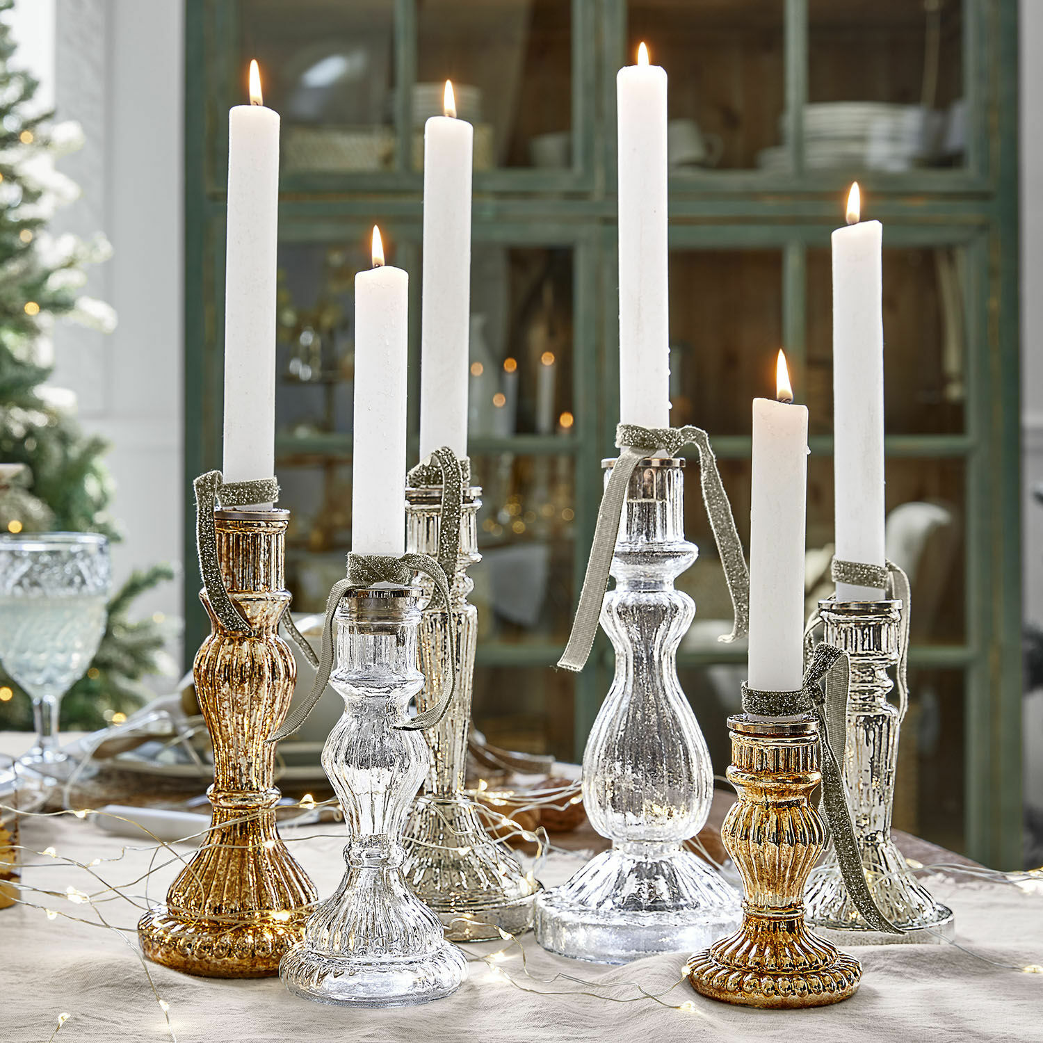 Kerzenständer 6er Set Quirène Set aus gold- und silberfarbenen Glas-Kerzenhaltern mit weißen Kerzen auf festlich gedecktem Tisch