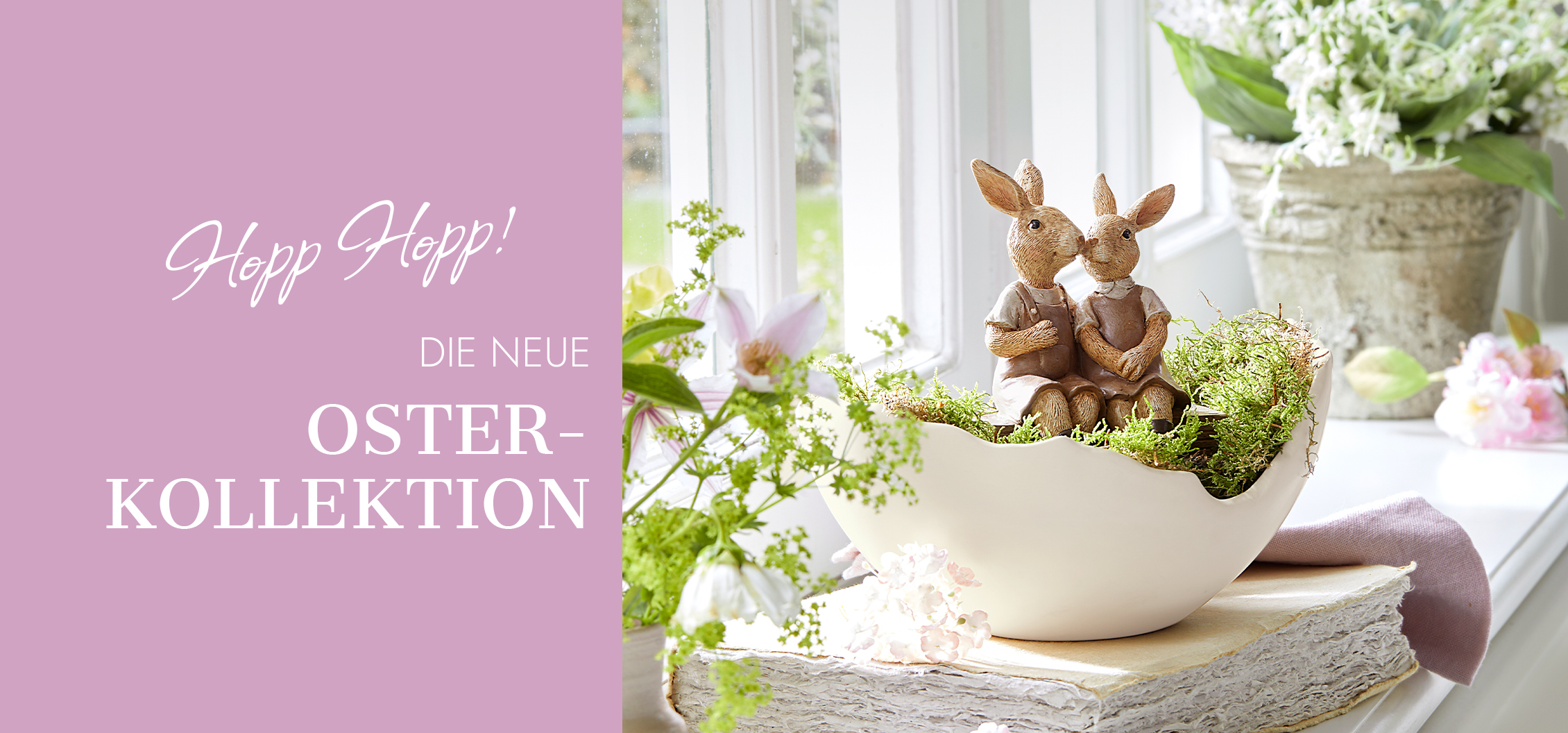 Osterdekoration mit weißer Keramikschale und Hasenfiguren umgeben von grünem Moos und Blumen