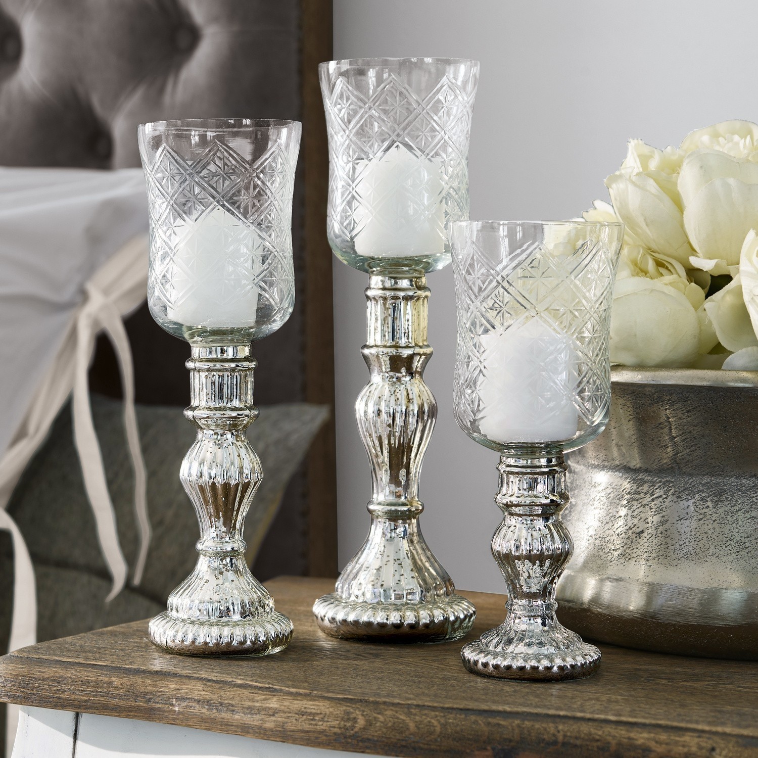 Windlicht 3er Set Celestin Drei silberne Kerzenhalter aus Glas mit Metallfuß auf einem Holztisch dekorativ arrangiert