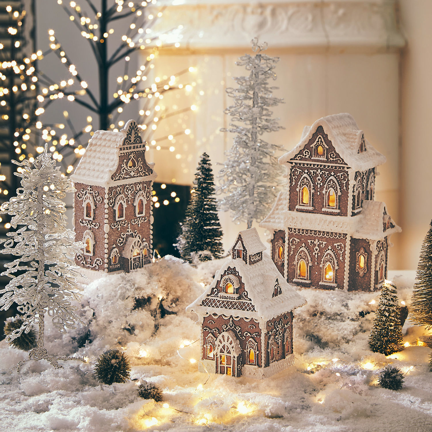 LED-Dekohaus 3er Set Anyama Dekorative Lebkuchenhäuser mit weißem Zuckerguss und Lichtern auf schneebedecktem Untergrund mit Tannen