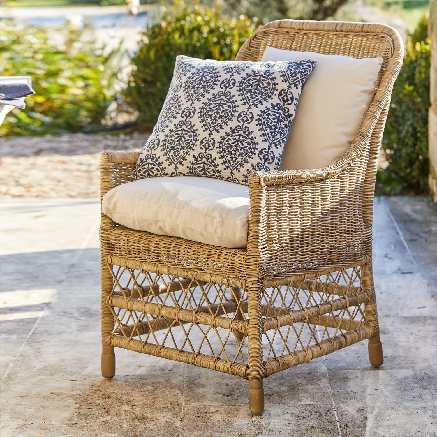 Sessel Giepmare Rattansessel mit cremefarbenen Polstern und blau gemustertem Zierkissen, Gartenmöbel im Freien