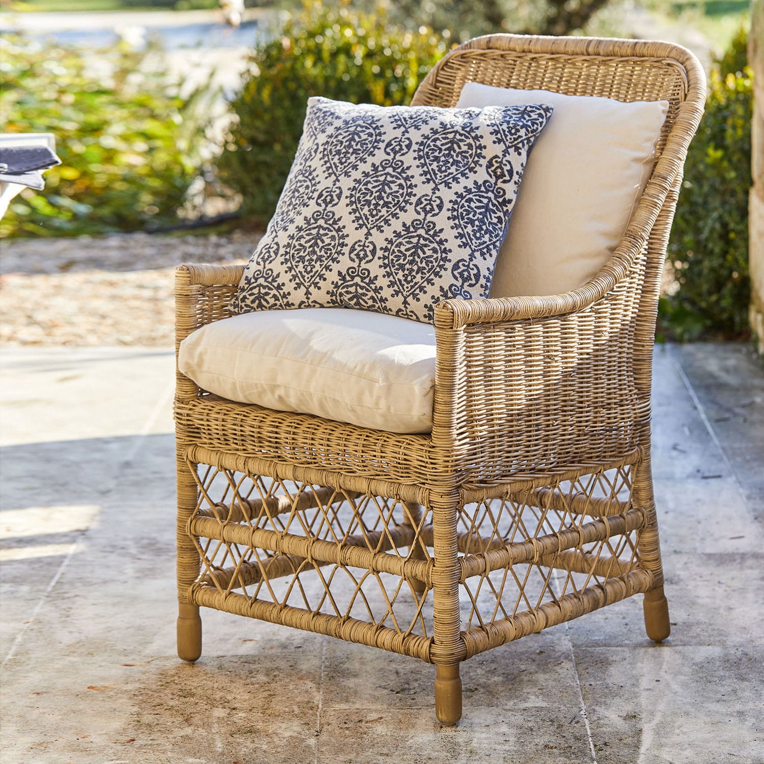 Sessel Giepmare Rattansessel mit cremefarbenen Polstern und blau gemustertem Zierkissen, Gartenmöbel im Freien
