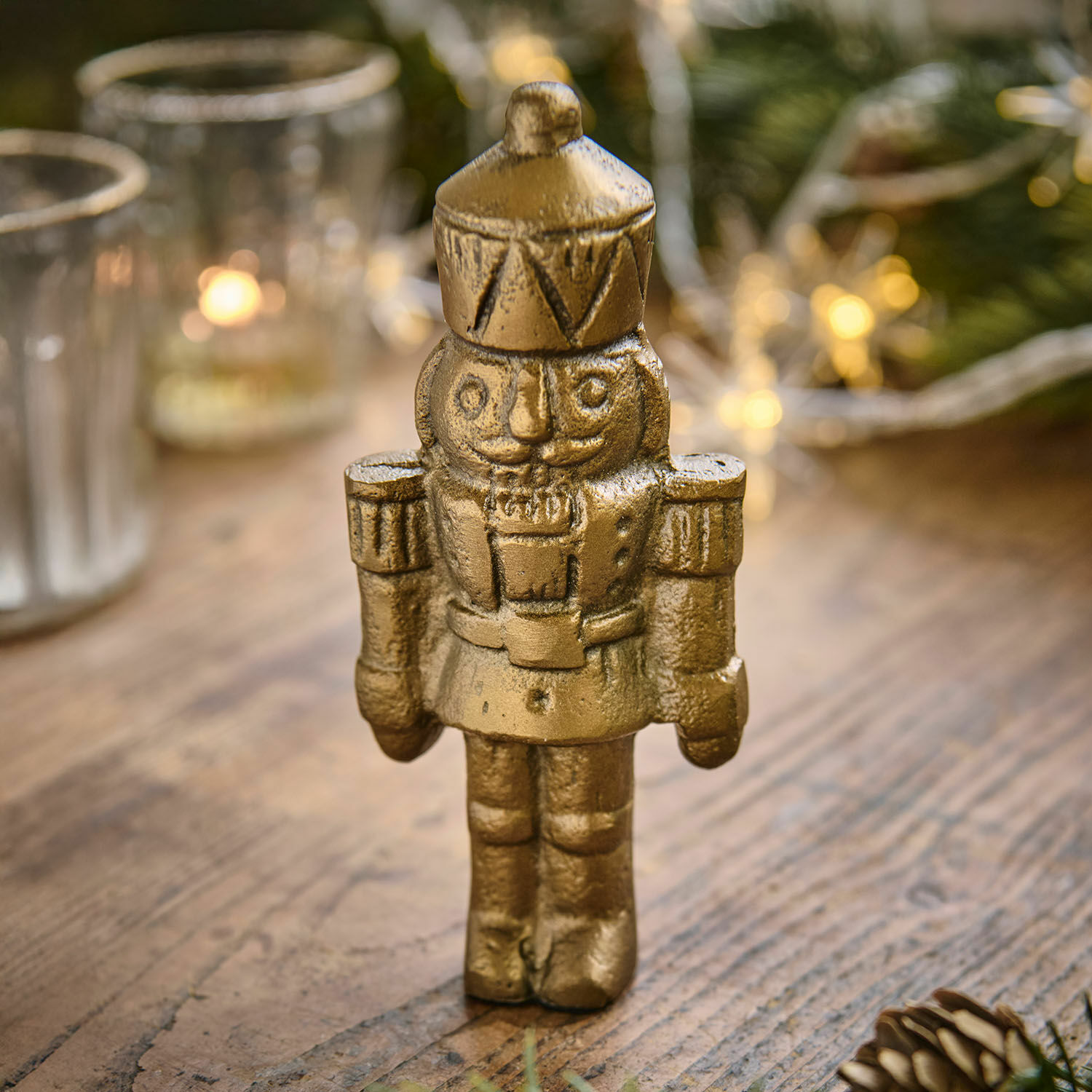 Deko-Figur Zarilith Goldfarbener Nussknacker aus Metall auf Holztisch, festliche Weihnachtsdekoration