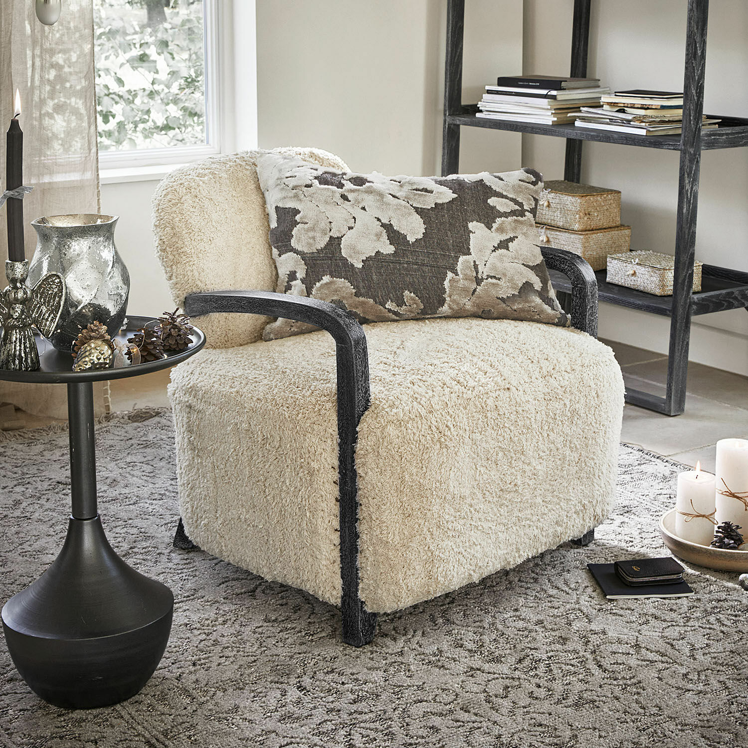 Bequemer Sessel mit cremefarbenem, flauschigem Bezug und schwarzen Holzarmlehnen im Wohnzimmer