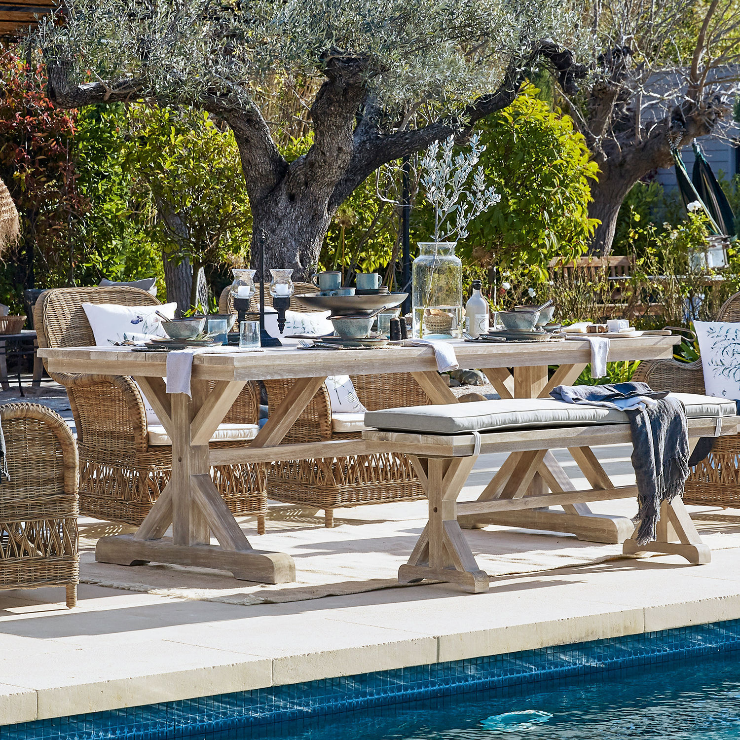 Tisch FSC®-100% Graslin Heller Holzesstisch mit Rattanstühlen am Pool in natürlicher Gartenumgebung für Outdoor-Essbereich