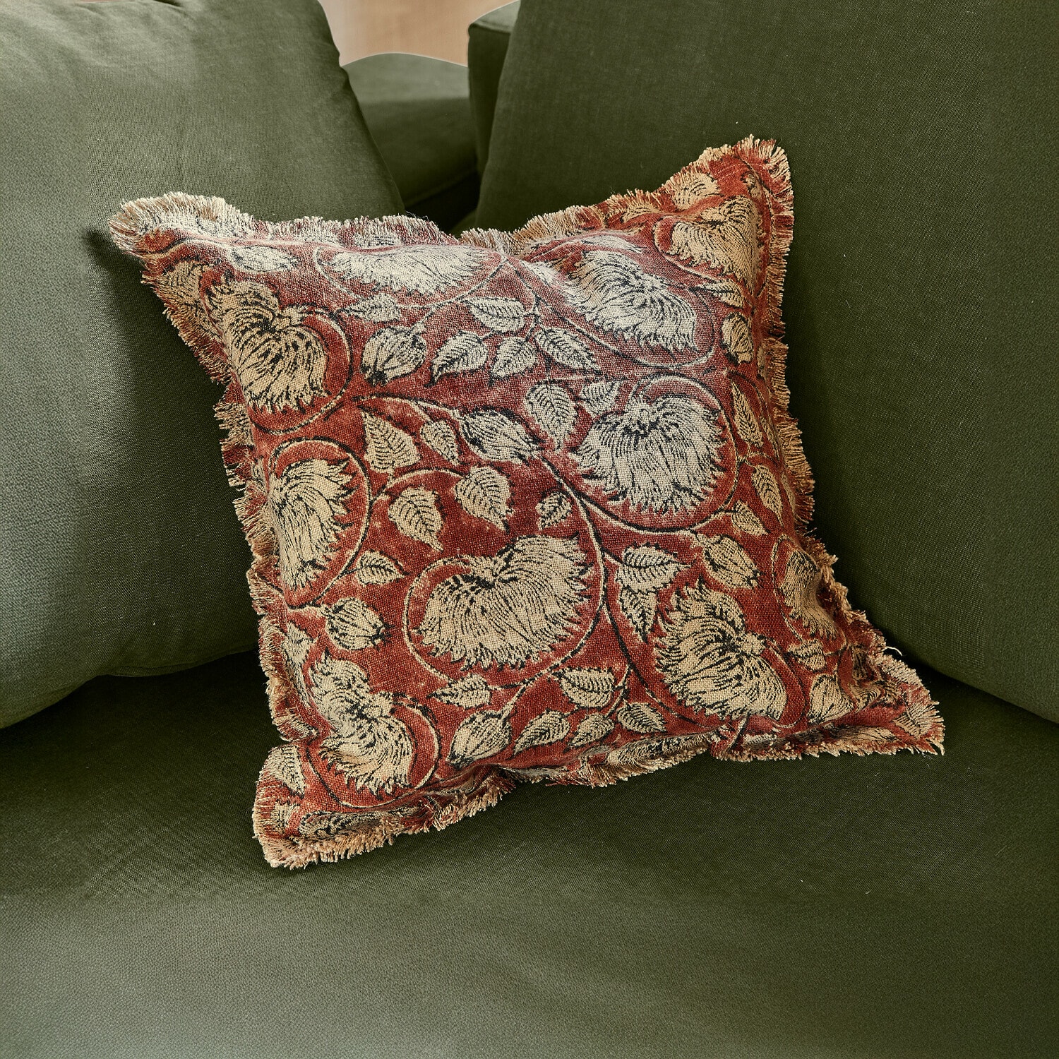 Kissenhülle Lemisto Dekoratives Kissen aus Stoff mit rot-beigem Blumenmuster auf grünem Sofa