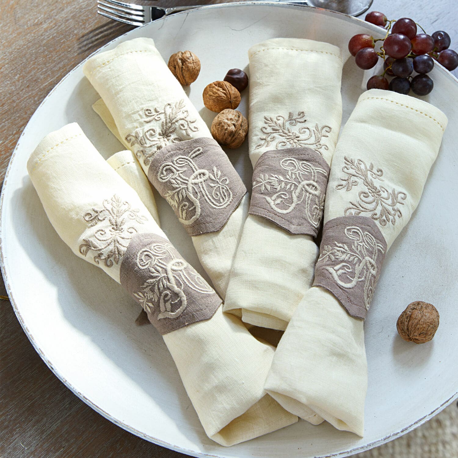 Servietten 4er Set Claudine Set aus cremefarbenen Leinenservietten mit braunen bestickten Ringen für den Tisch
