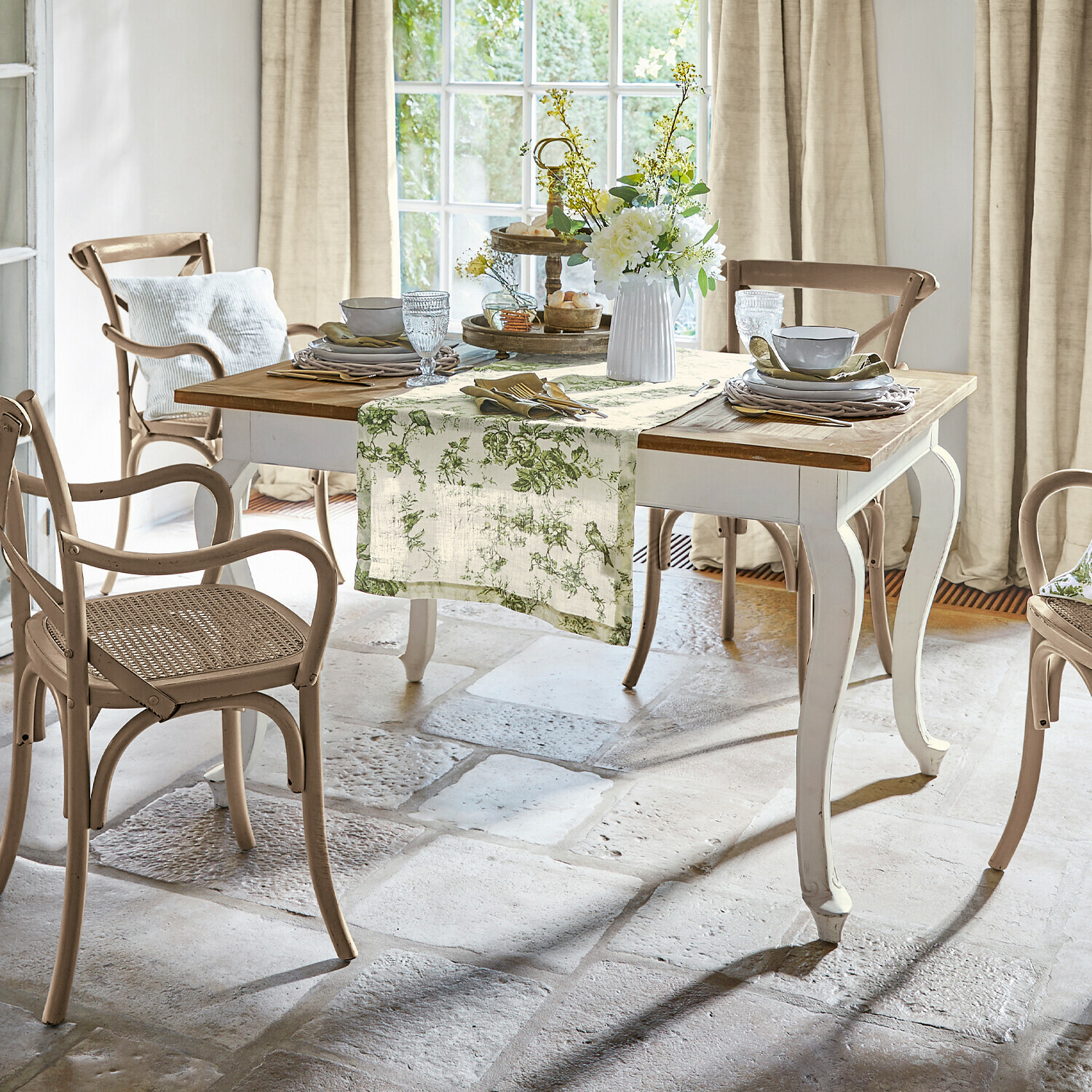 Tisch Plaish Esszimmer mit weißem Holztisch und beigen Rattanstühlen in natürlichem Landhausstil