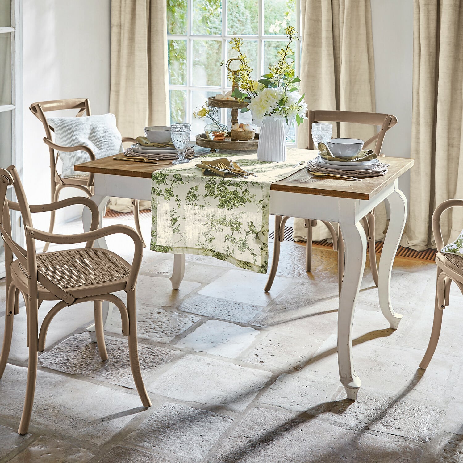 Tisch Plaish Esszimmer mit weißem Holztisch und beigen Rattanstühlen in natürlichem Landhausstil