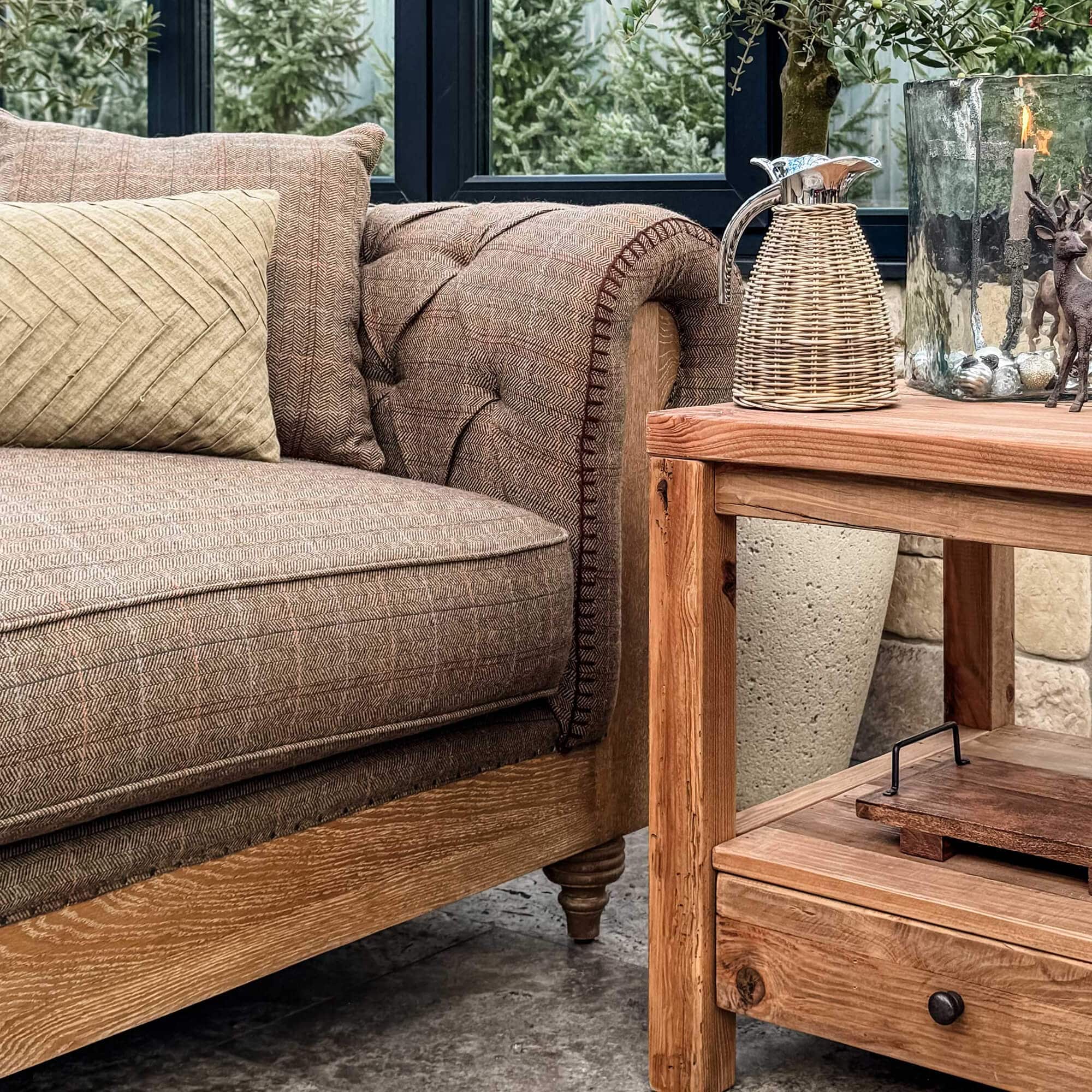 Braunes Stoffsofa mit Holzrahmen neben einem Holztisch mit weihnachtlicher Dekoration