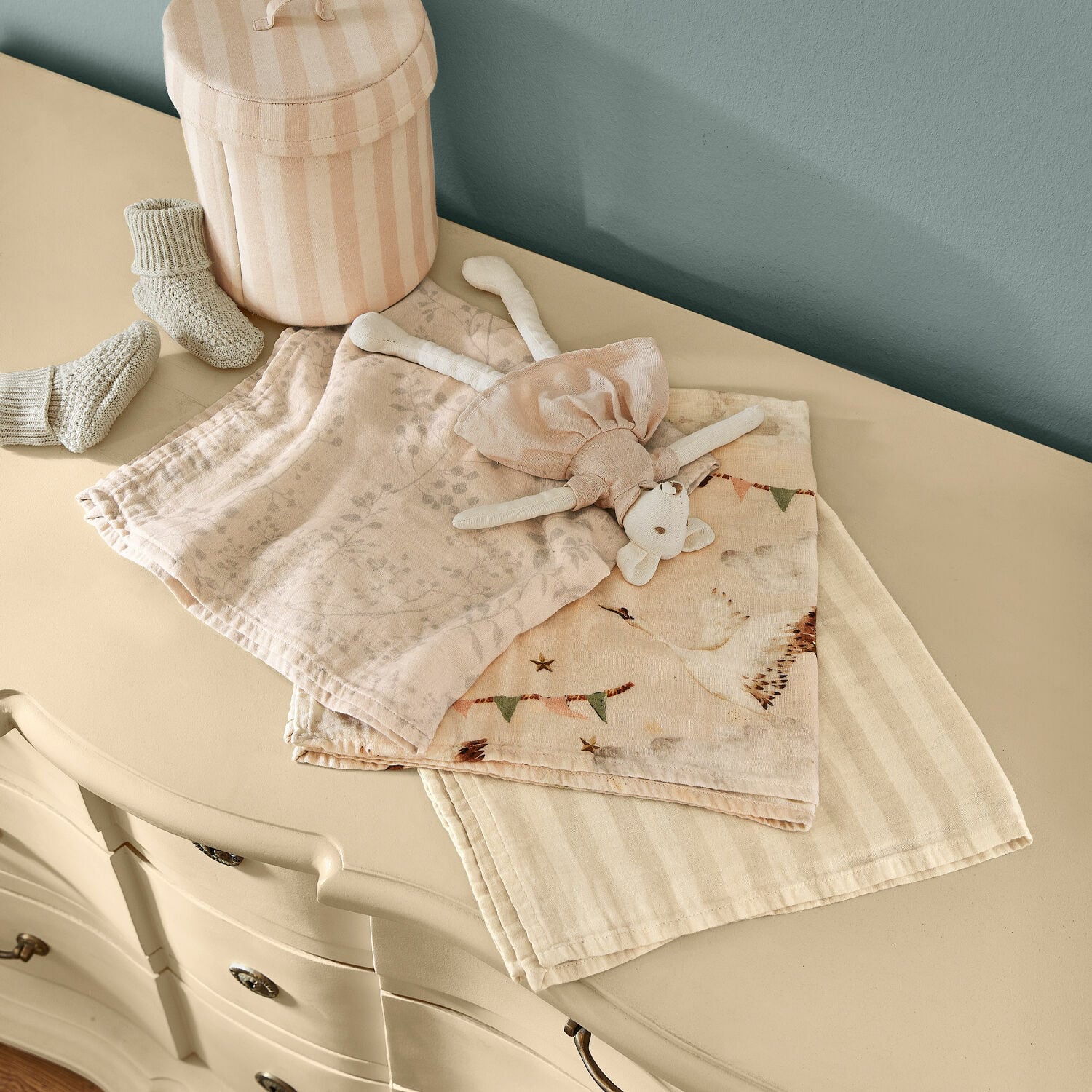 Babytuch 3er Set Bellise Zarte Baumwollwindeln und Plüschtier in Pastellfarben auf cremefarbener Kommode
