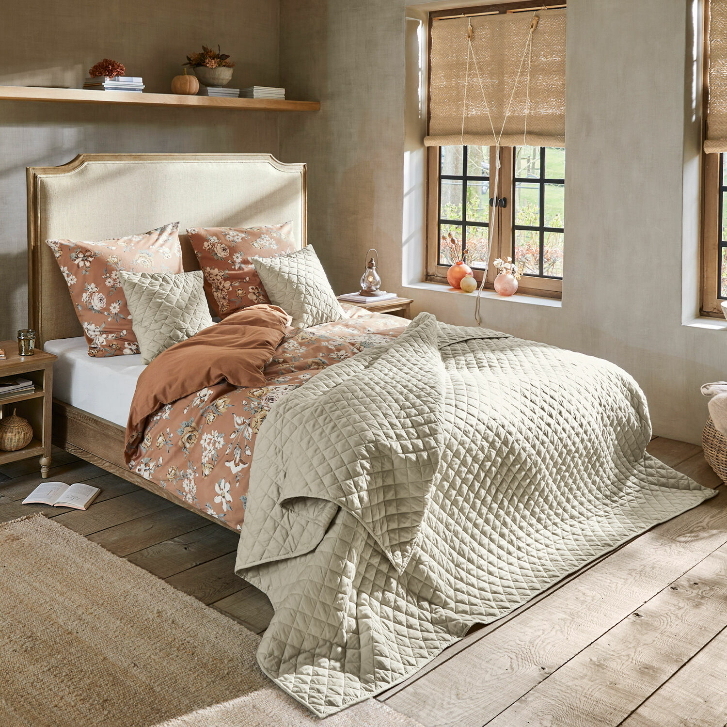 Bett Catham Gemütliches Schlafzimmer mit Bett in beiger Steppdecke und floraler Bettwäsche in warmen Farben