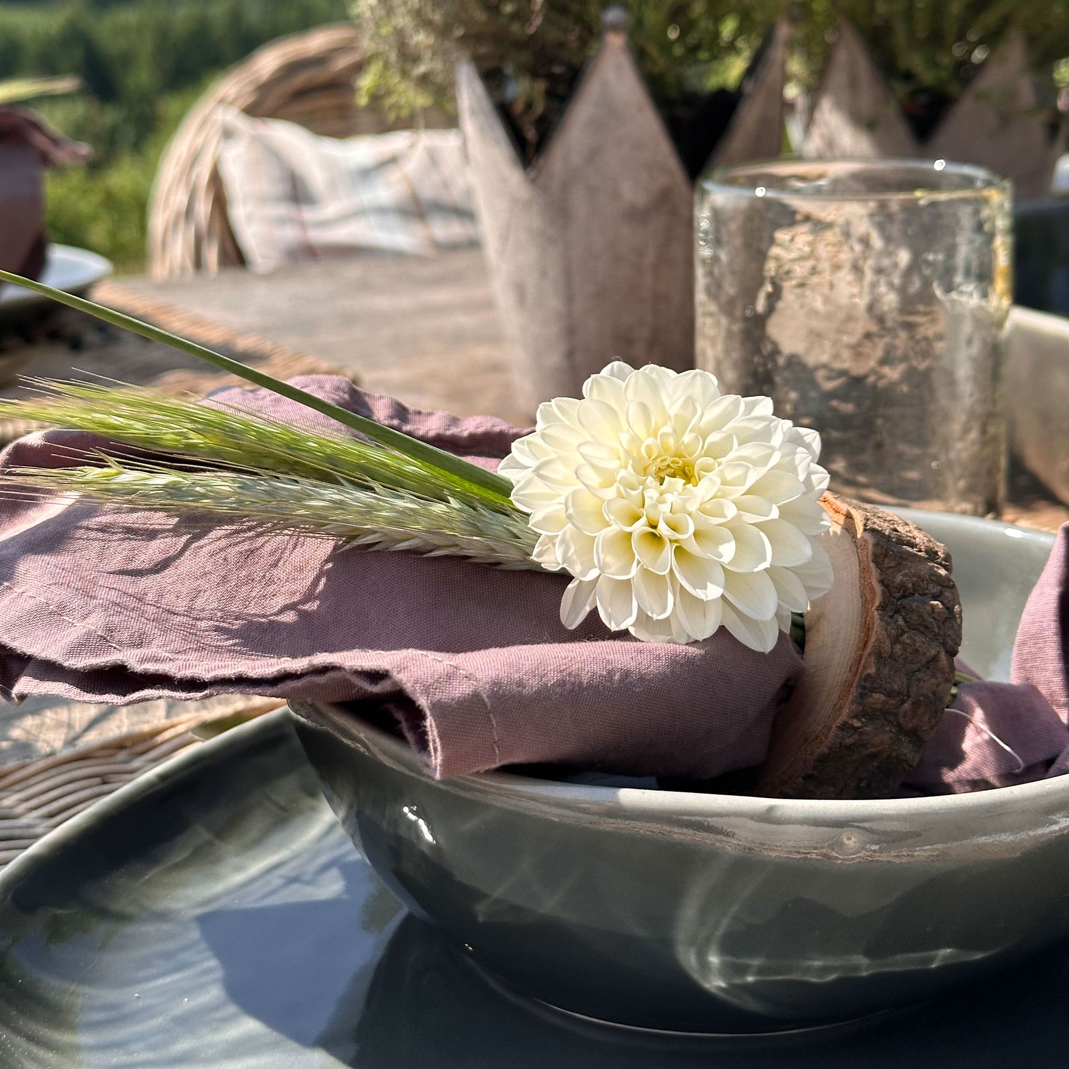 Weiße Blumen-Dekoration auf rosa Leinenserviette mit rustikalem Holzring
